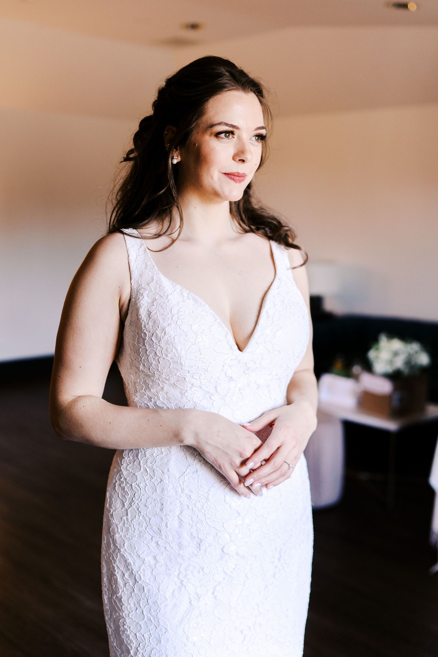 Romantic bridal portraits featuring a lace V-neck wedding dress in soft lighting.