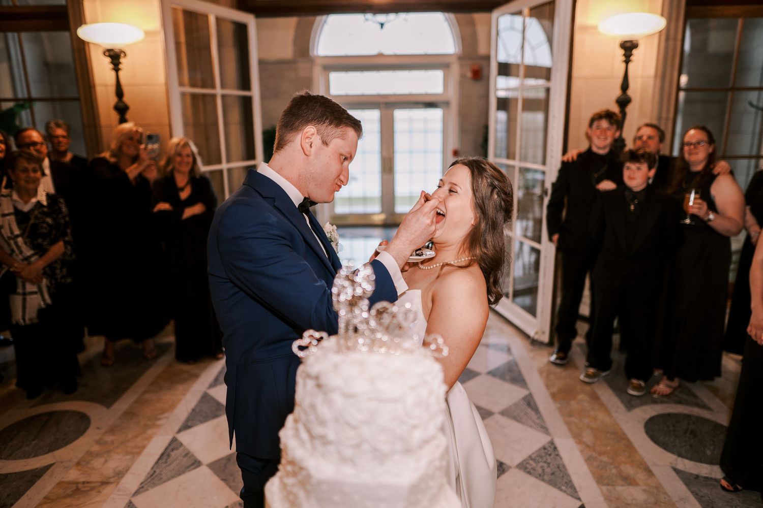Wedding celebration in an elegant ballroom with warm lighting and dancing couples.