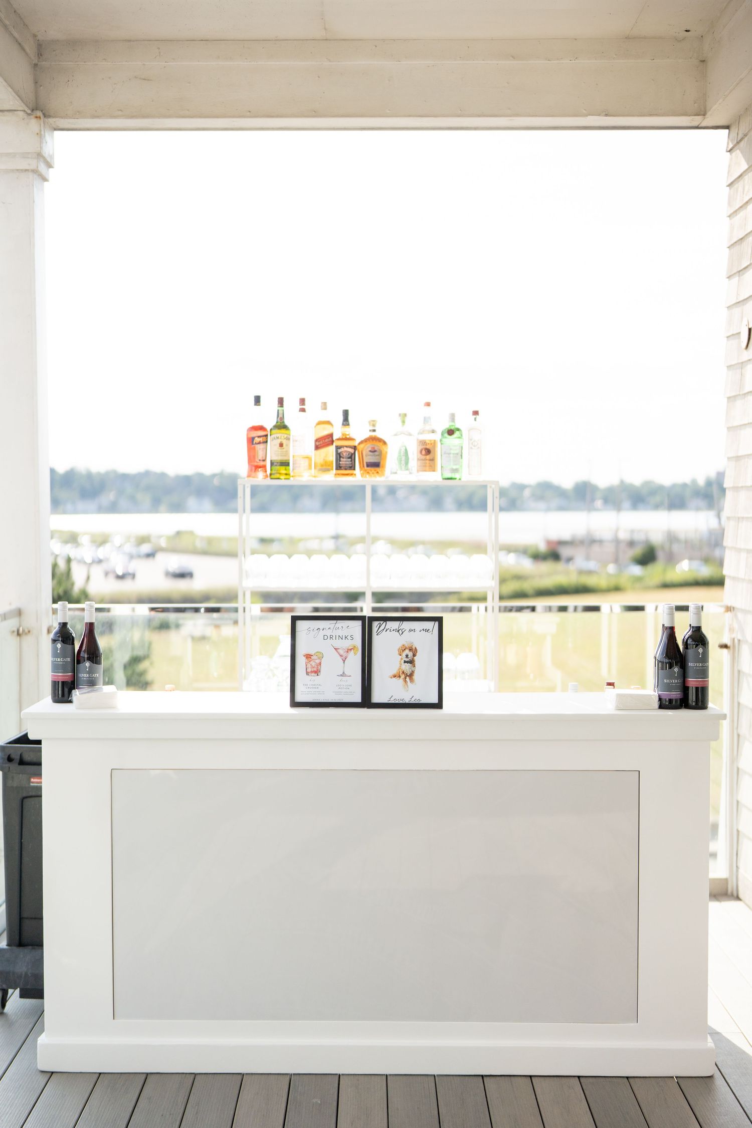 White modern bar counter with clean minimalist design overlooking an outdoor landscape through large windows.