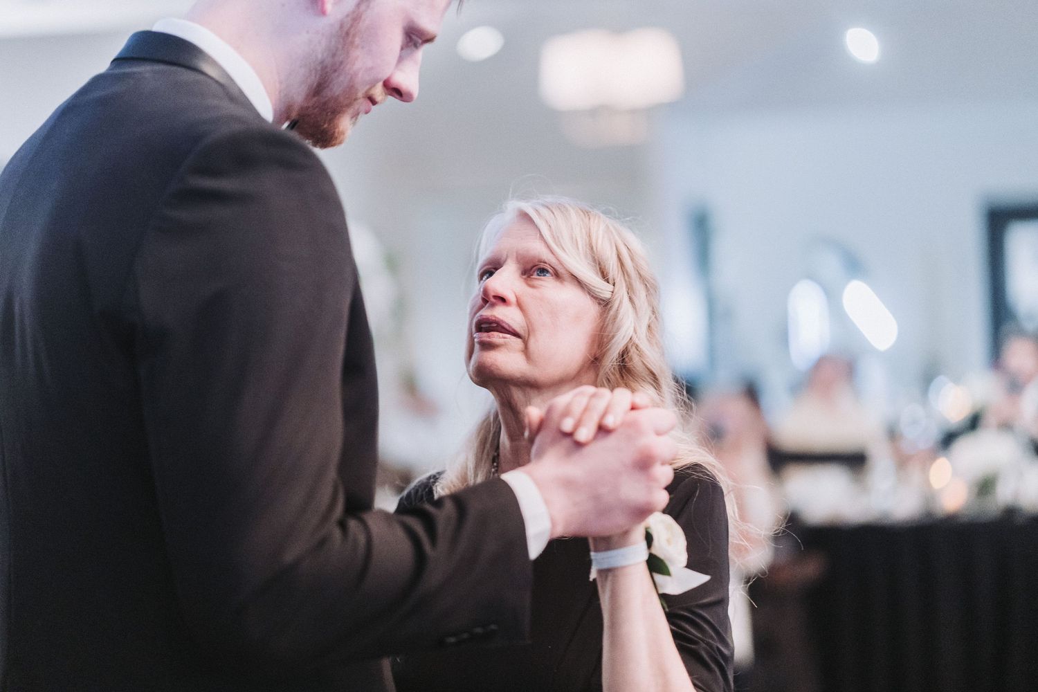 Wedding reception guests enjoying emotional moments during speeches.
