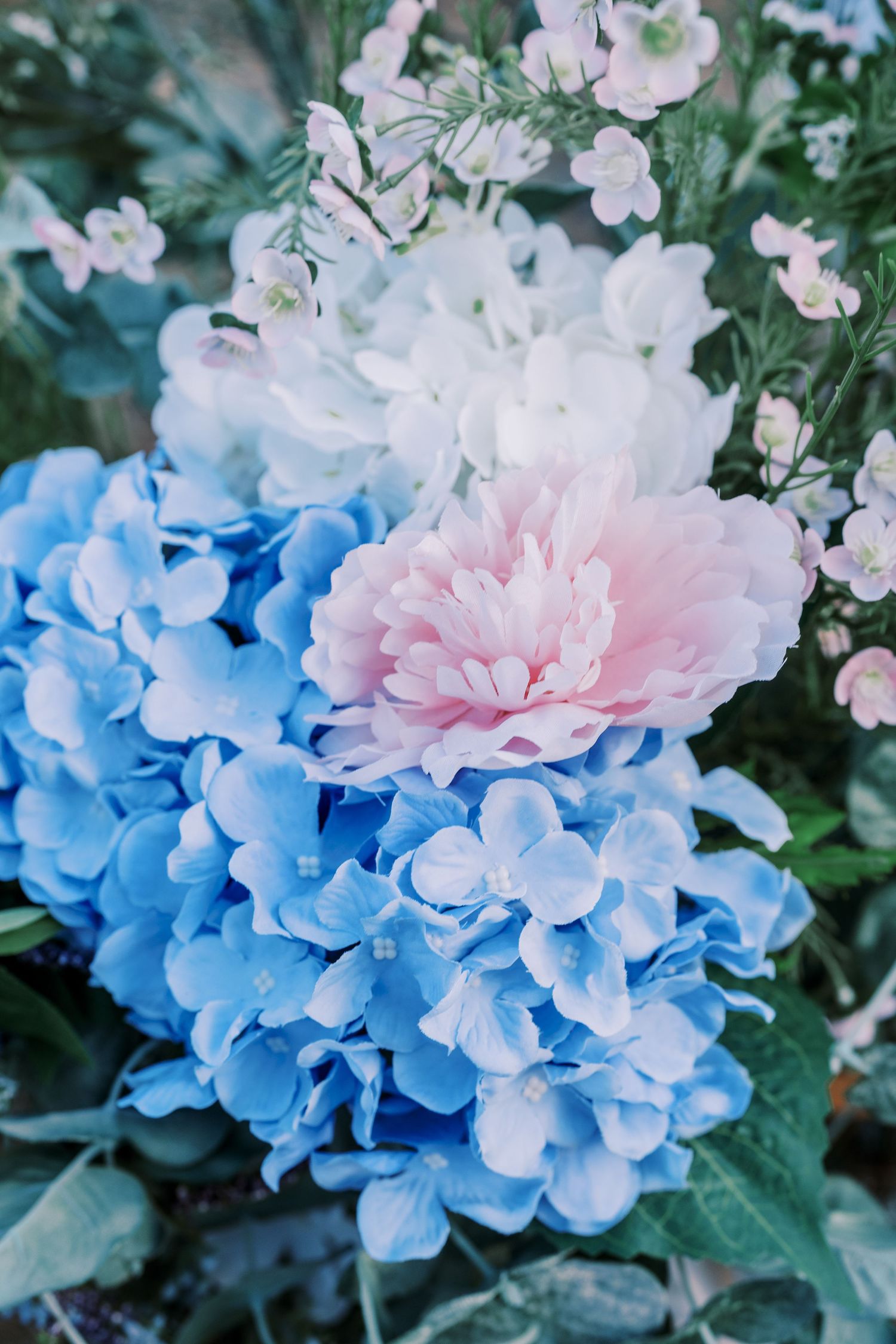 Beautiful blue hydrangea flowers and soft pink peonies create a romantic garden display.