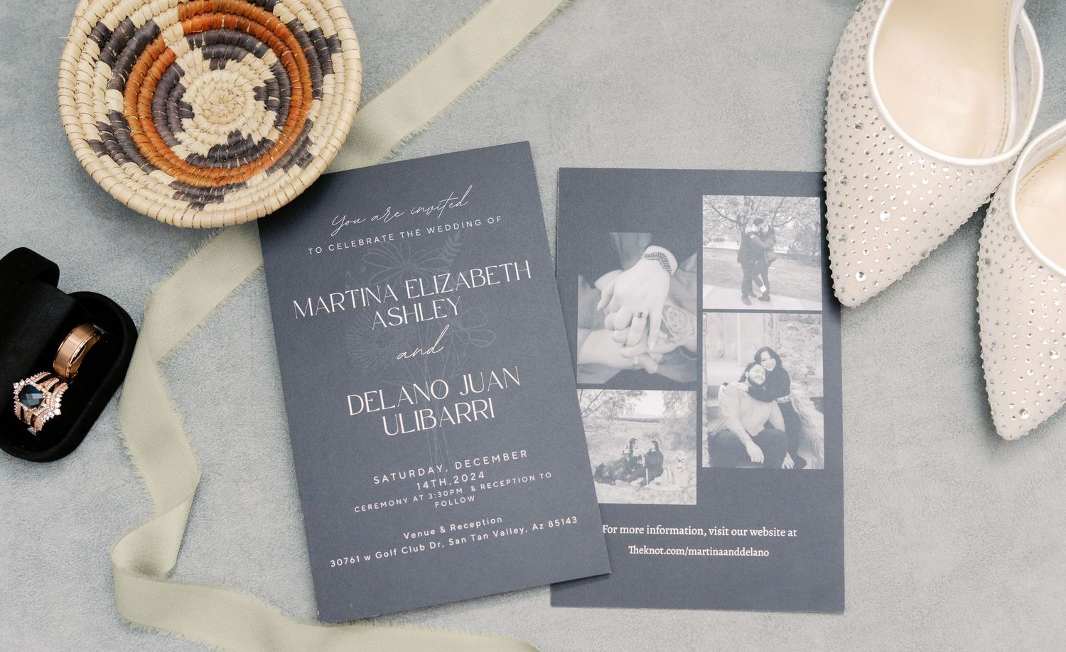 Modern gray wedding invitation with black and white photos laid flat next to white bridal shoes and jewelry box.