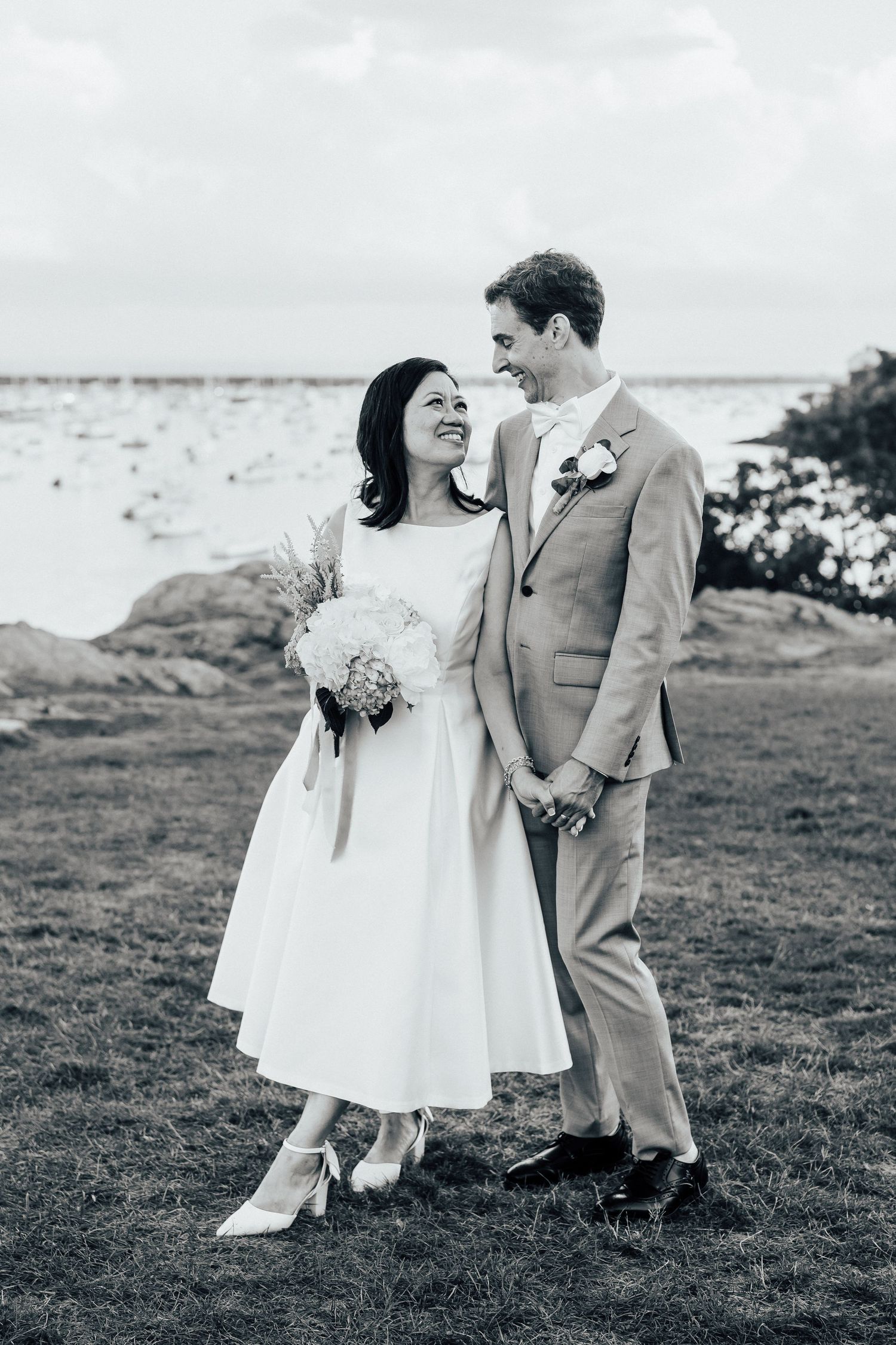 A black and white wedding photoshoot on a scenic coastal clifftop with ocean views.