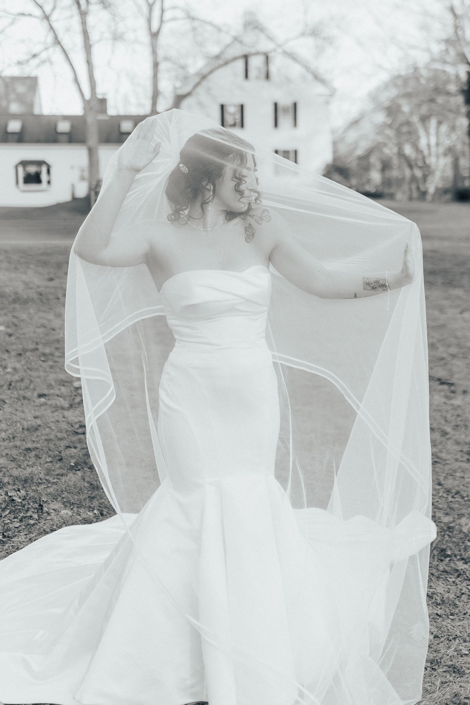 A bride in a flowing white wedding dress twirls gracefully in a garden setting, creating a dreamy ethereal effect.
