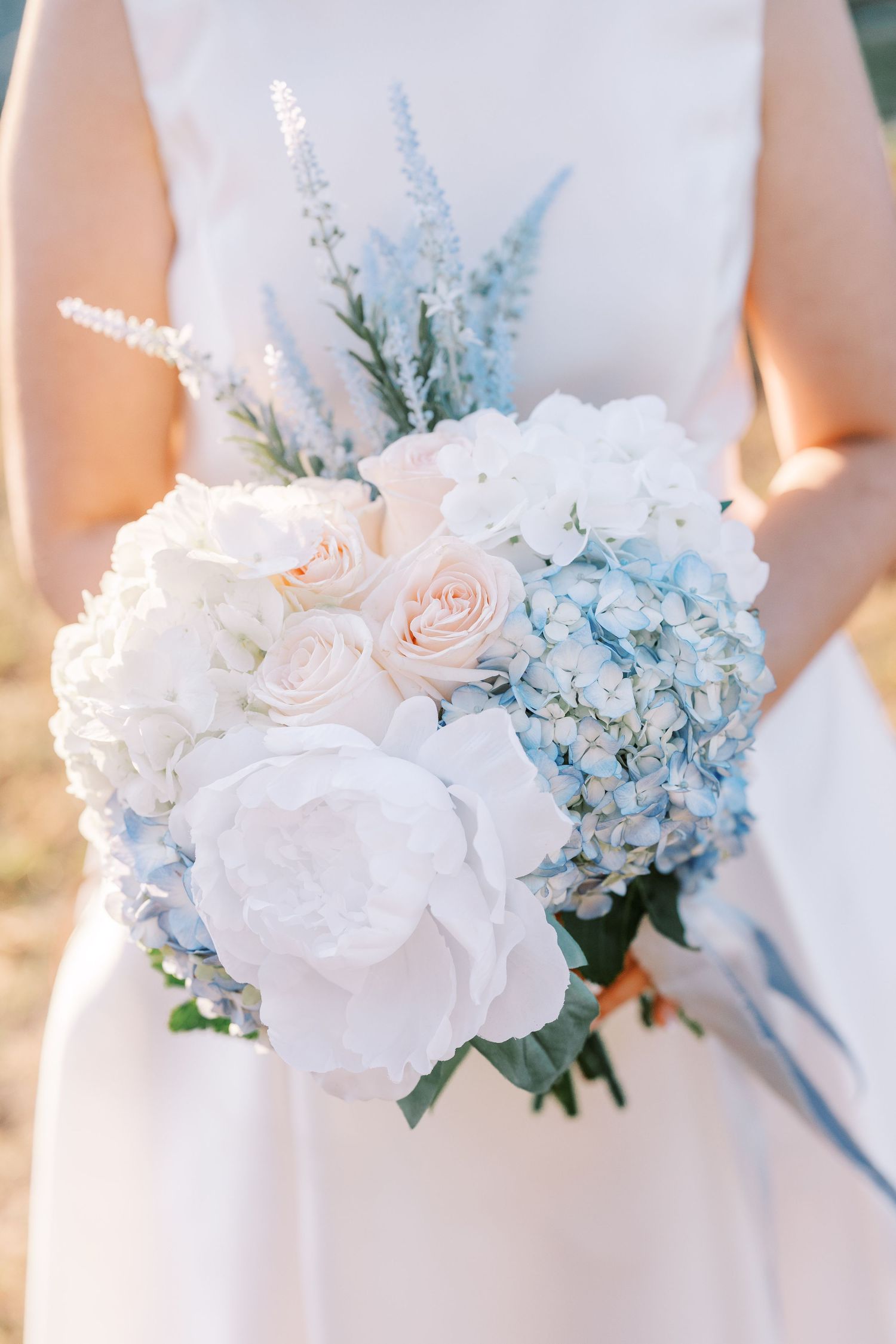 Elegant wedding bouquets featuring white roses and light blue hydrangeas arranged in a delicate sequence.