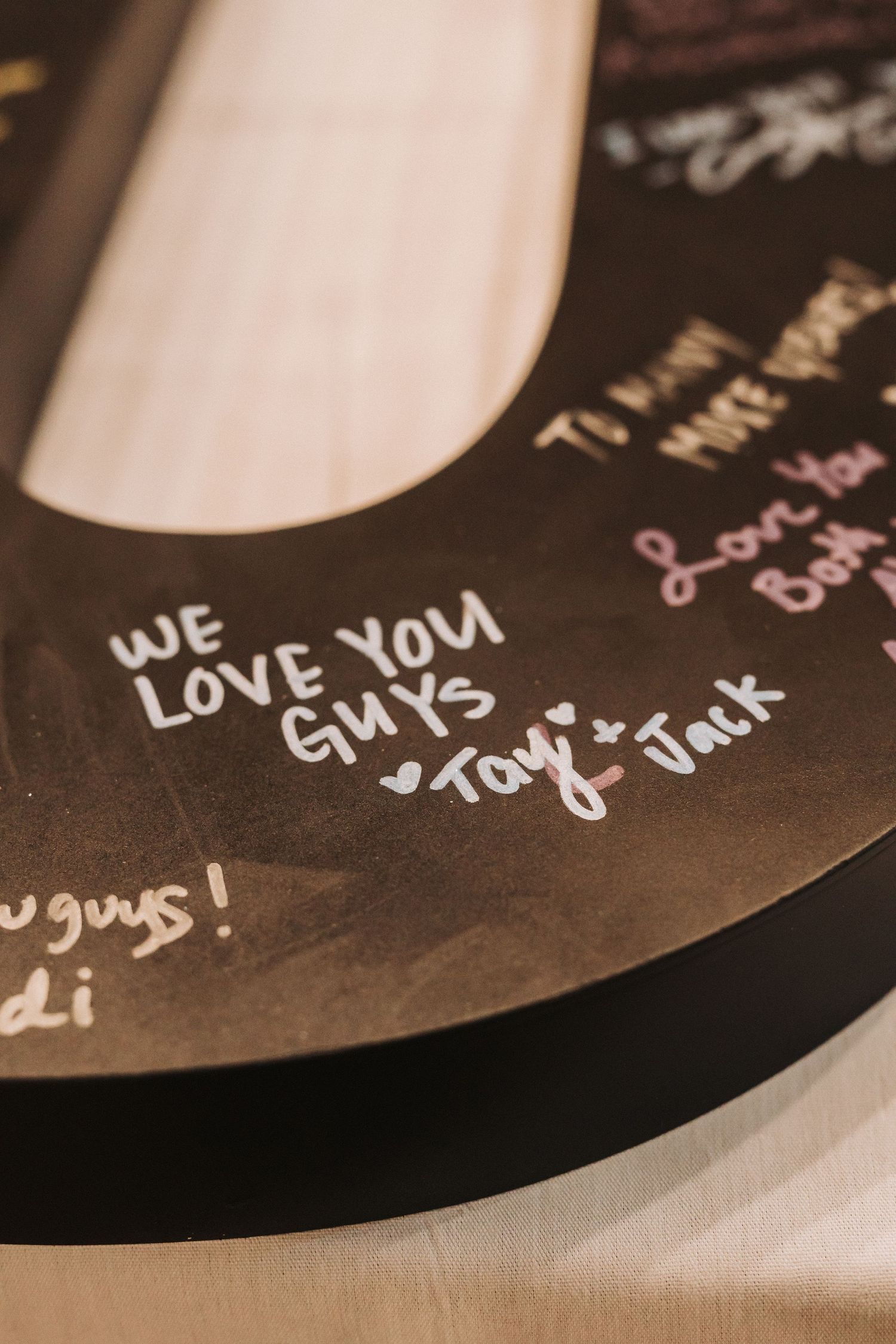 A handwritten message reading 'We Love You Guys' appears on what appears to be a dark vinyl record surface.