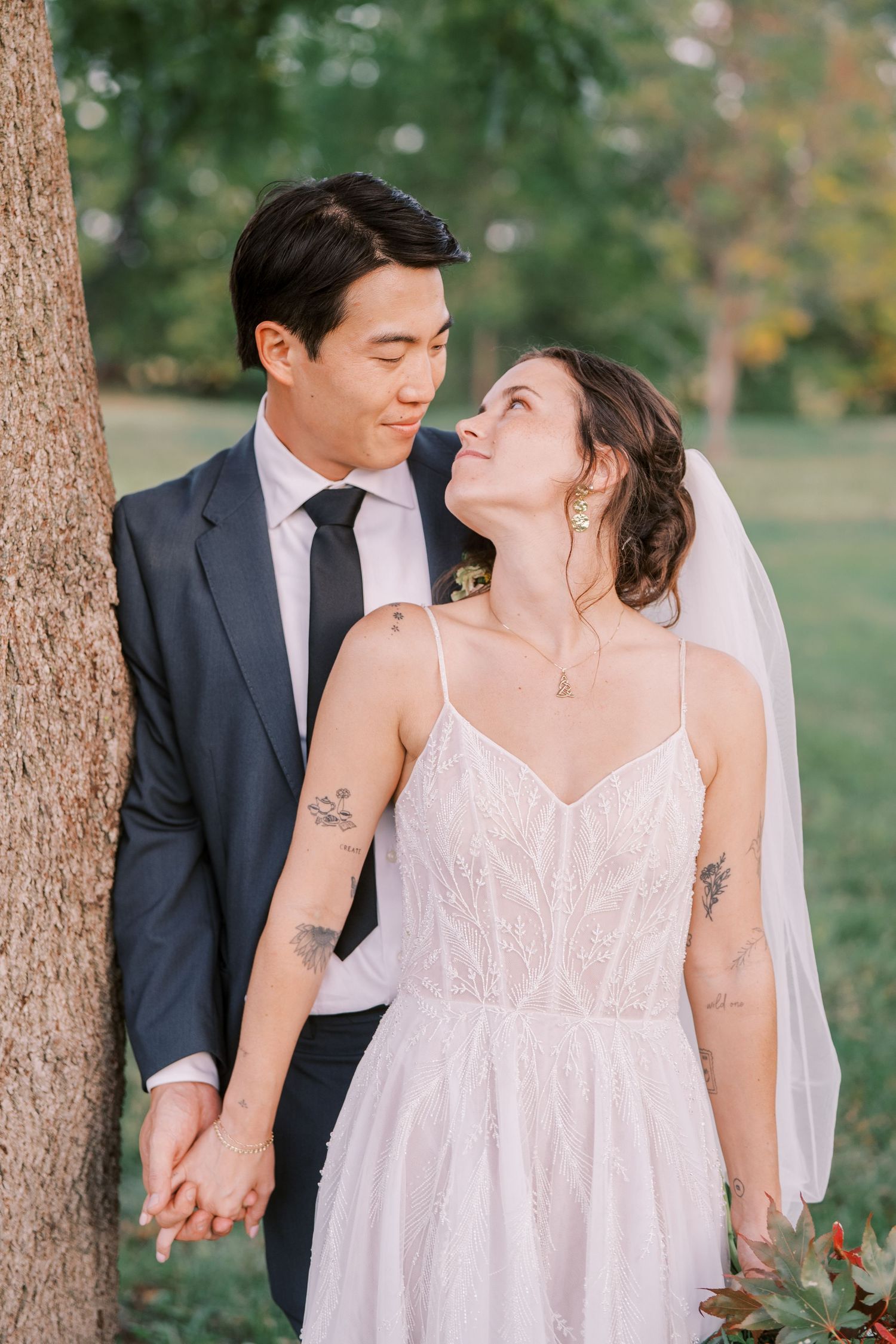 Intimate wedding portraits among pine trees showing couple in white dress and dark suit.