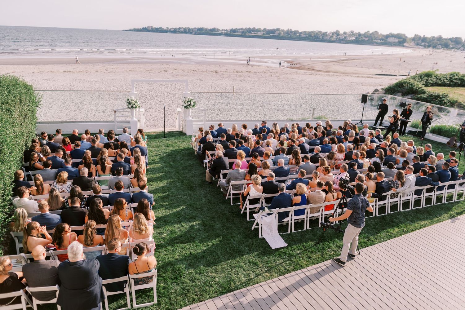 Panoramic collage of an outdoor wedding ceremony setup with wooden chairs on a grassy lawn overlooking a waterfront view.