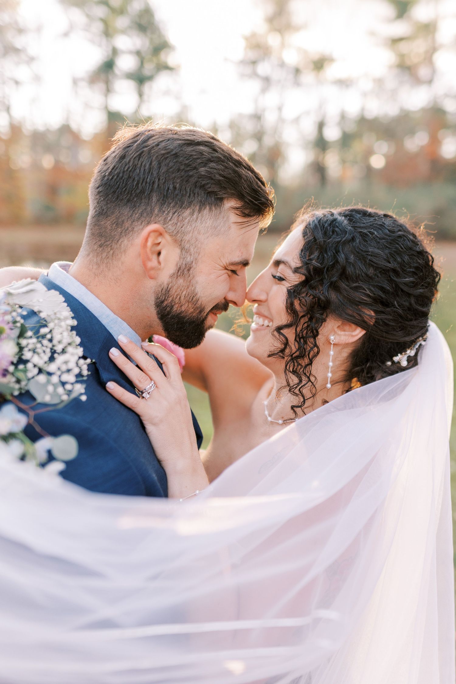 Romantic wedding couple embraces under flowing white veil in three artistic outdoor portrait shots.