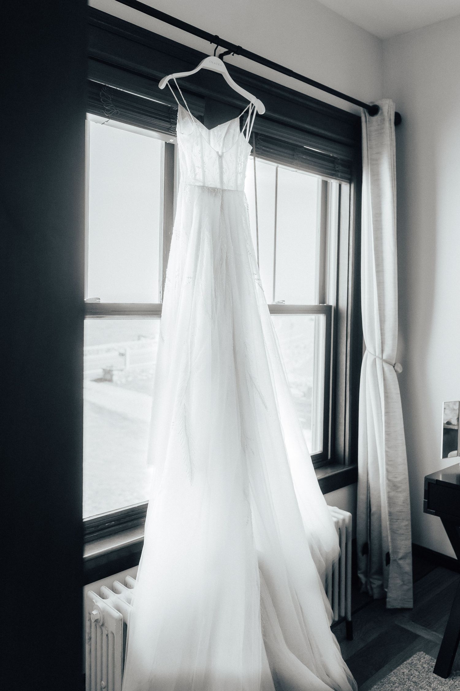 Minimalist interior with white flowing curtains and black window frames creating a dramatic contrast.