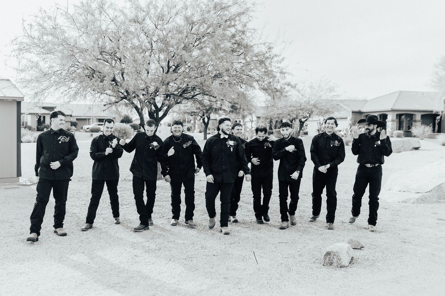 A group of uniformed officers stand in a row under a blooming cherry tree in this vintage black and white photograph.