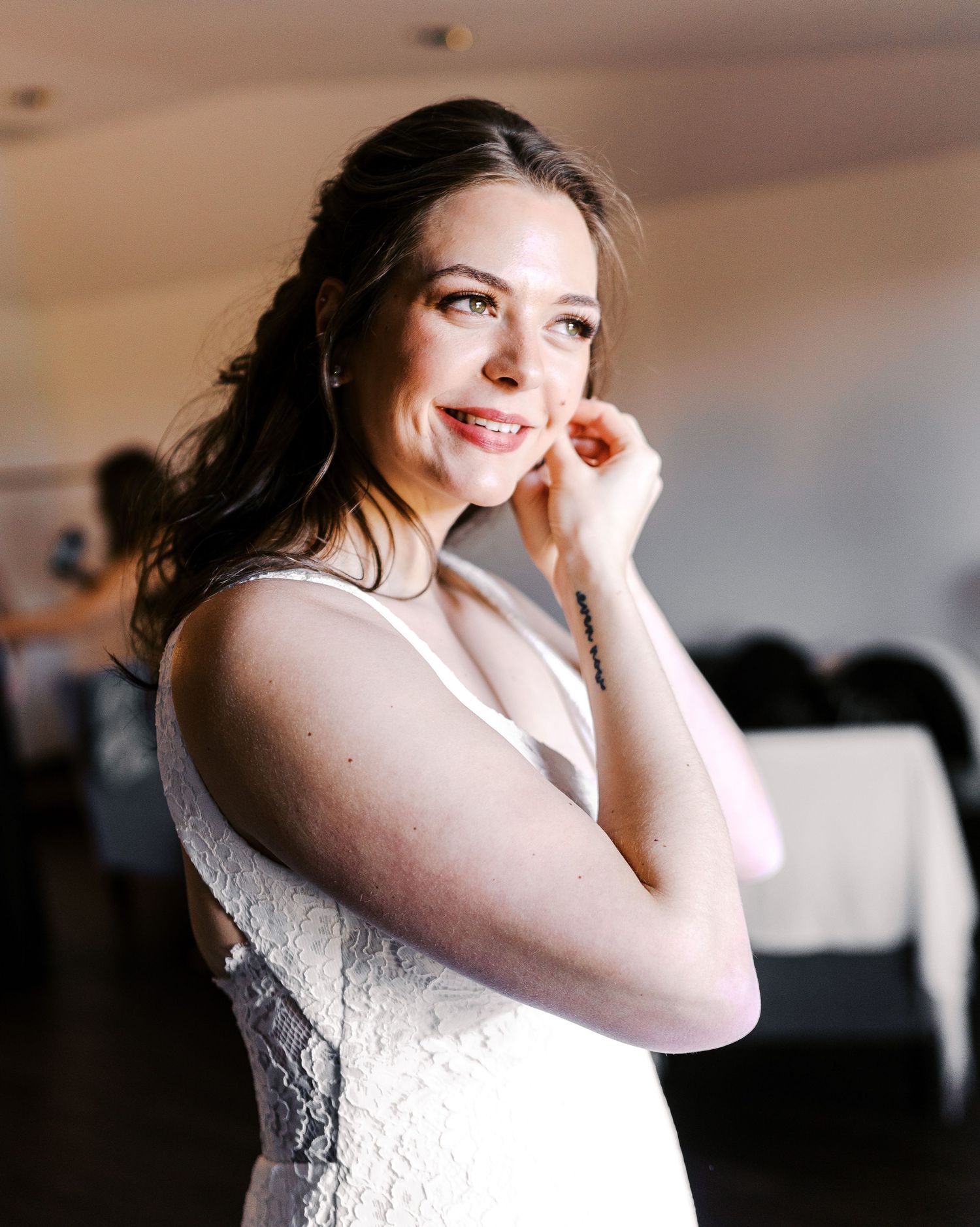 A bride poses in an elegant white lace wedding dress during her special day.
