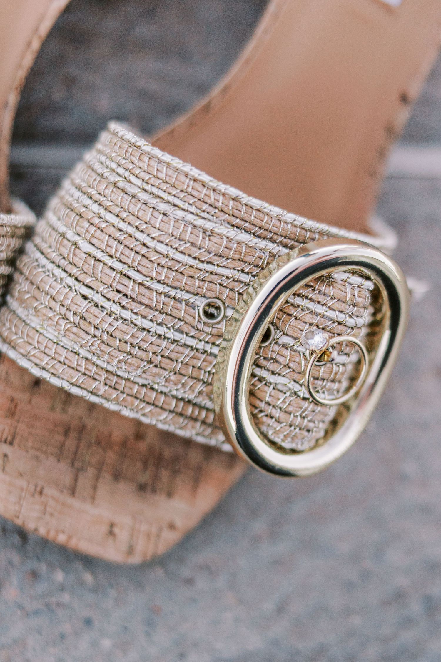 Close-up of sparkly gold sandal buckle with textured strap detail.
