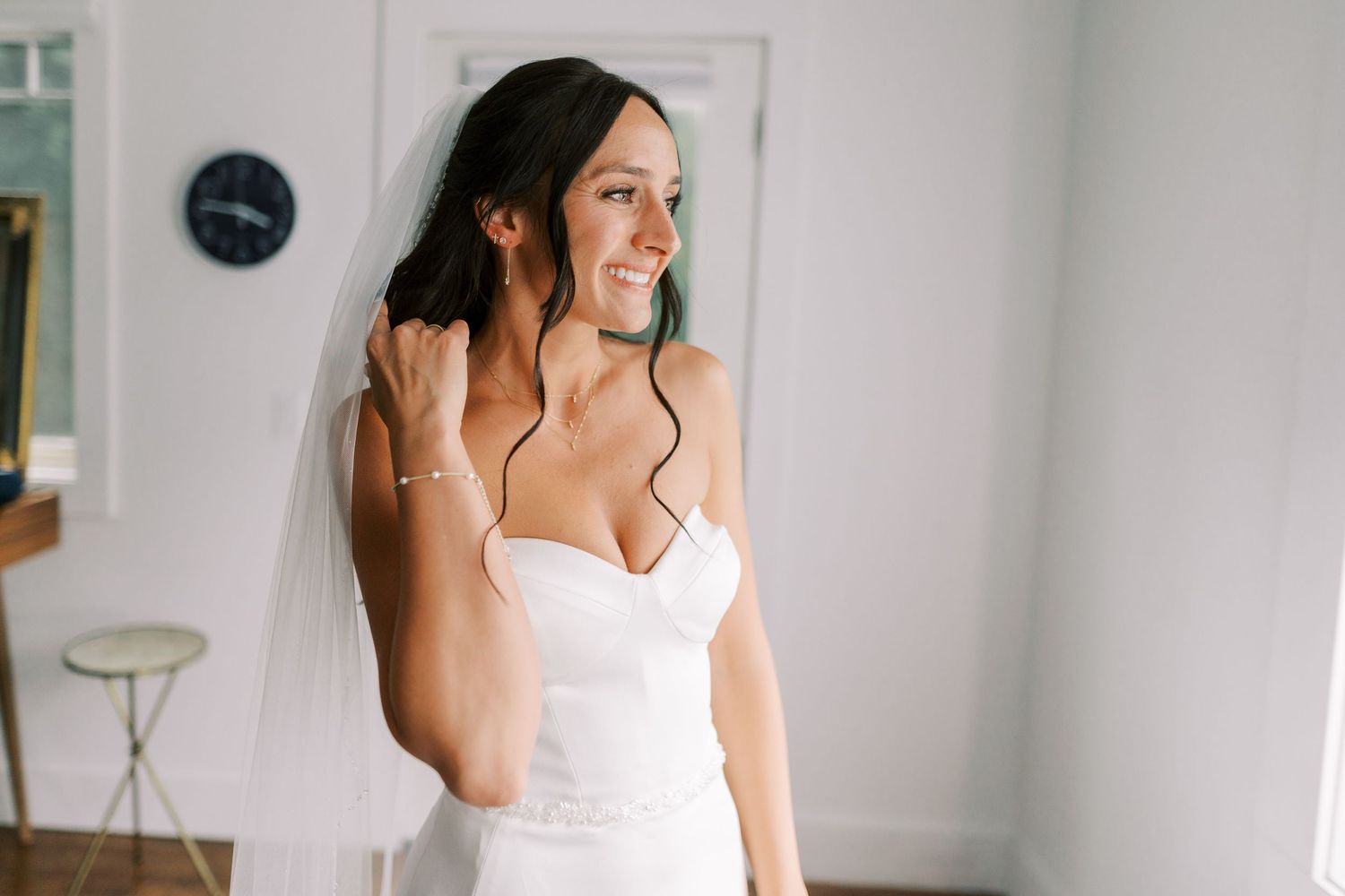 An elegant bride wearing a strapless white wedding gown and veil.