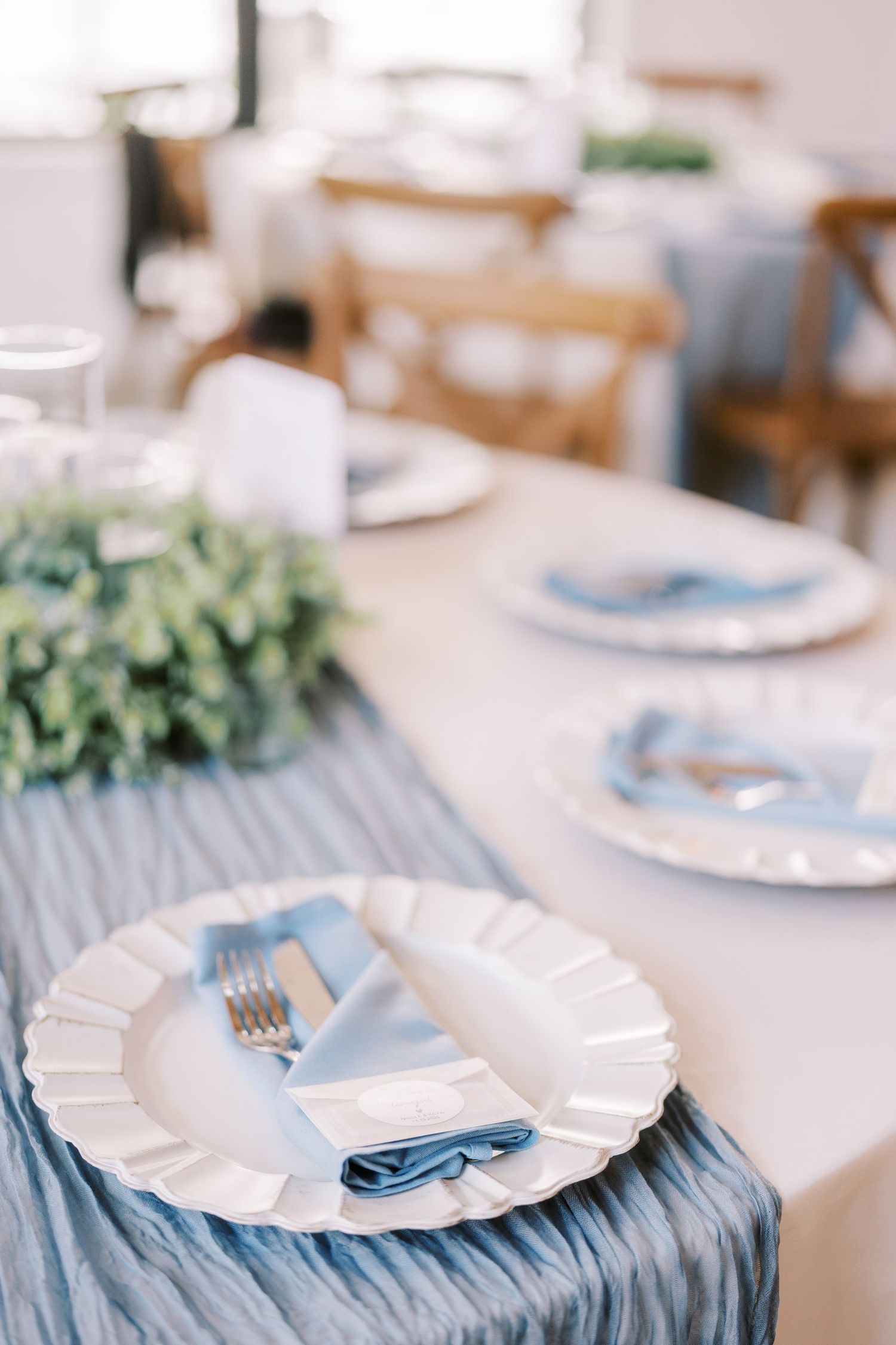 Elegant table setting with white plates and blue napkins arranged on a textured tablecloth for a formal event.