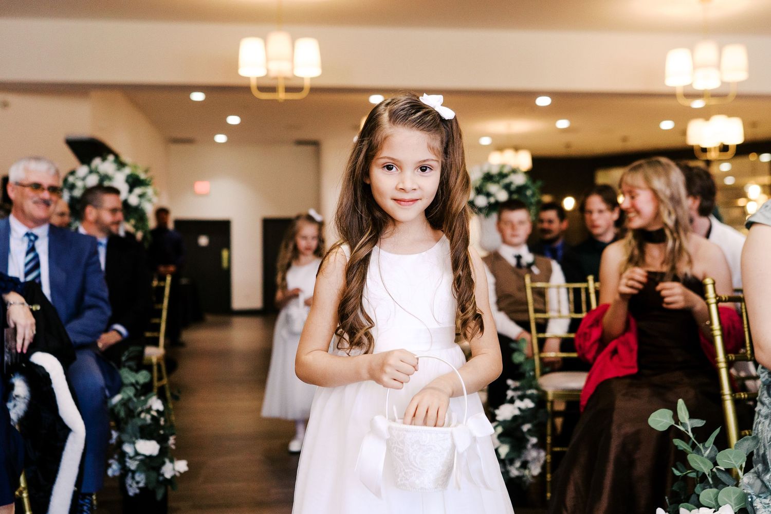 Wedding guests celebrate at an elegantly decorated indoor reception with holiday decorations and soft lighting.