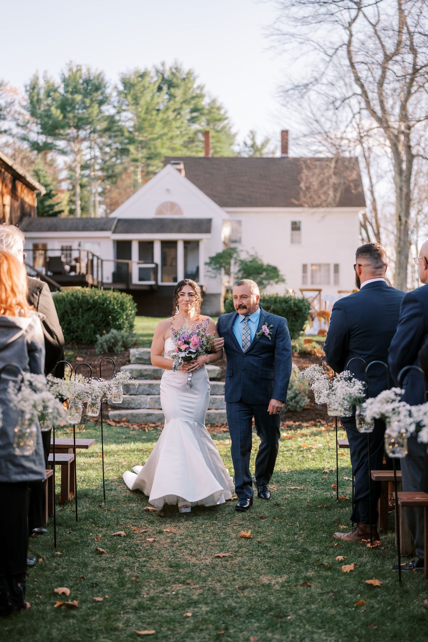 Wedding couple shares a playful moment sitting on chairs during an outdoor backyard ceremony.