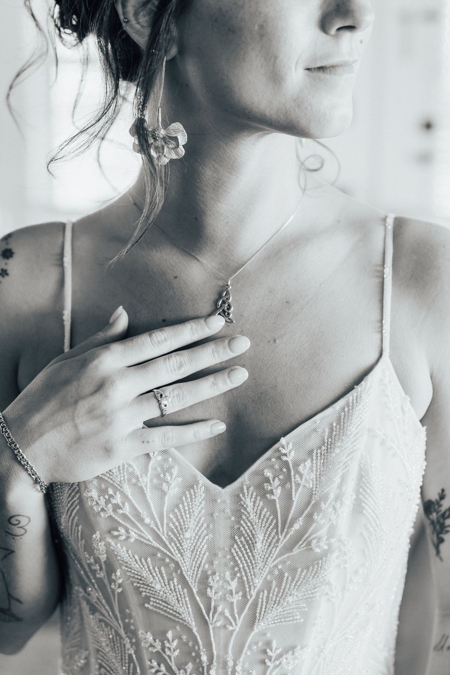 Elegant black and white detail shots of lace wedding dress bodice and jewelry.