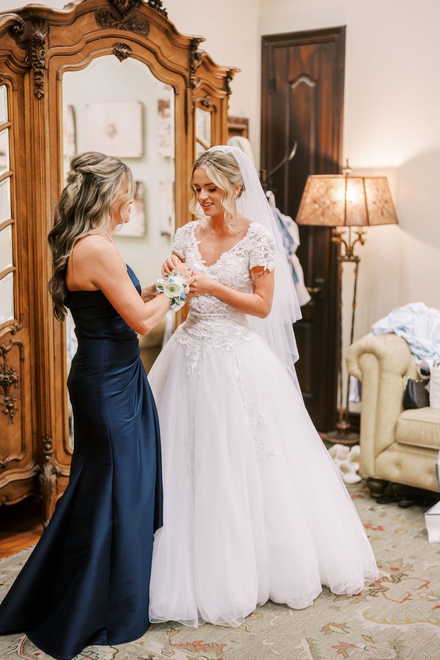 A heartwarming moment between two women in navy and white wedding attire as they share an emotional embrace.