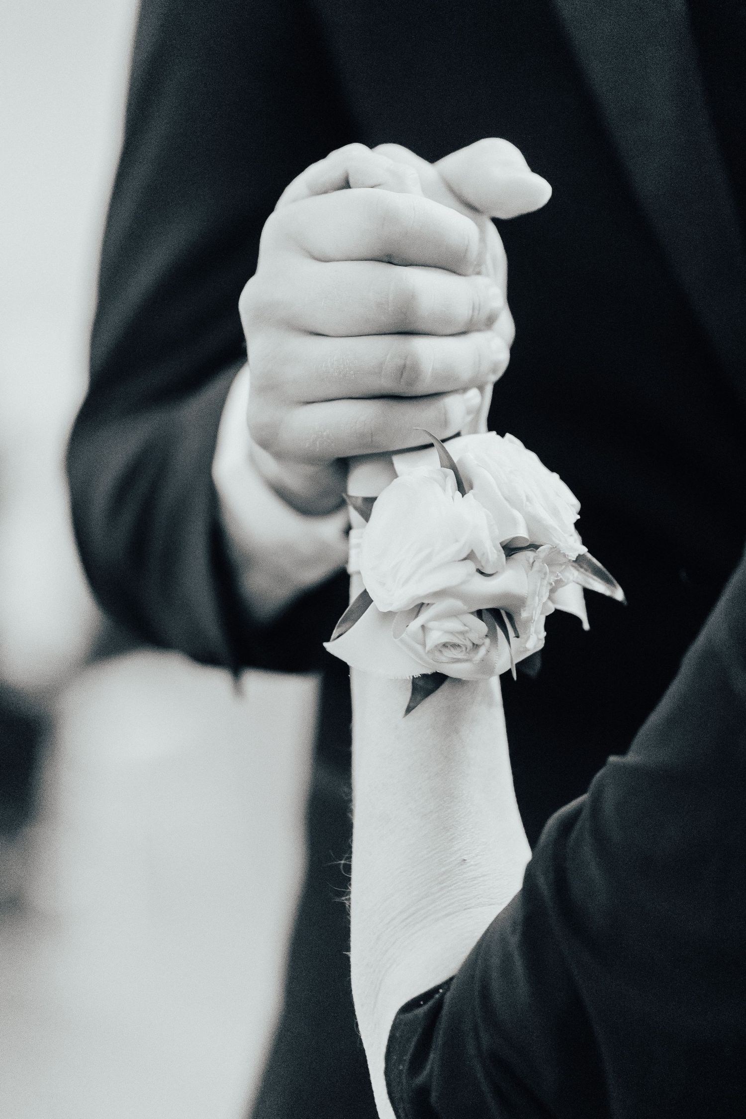 A sequence of black and white photos showing hands holding a crumpled white tissue paper against a dark background.