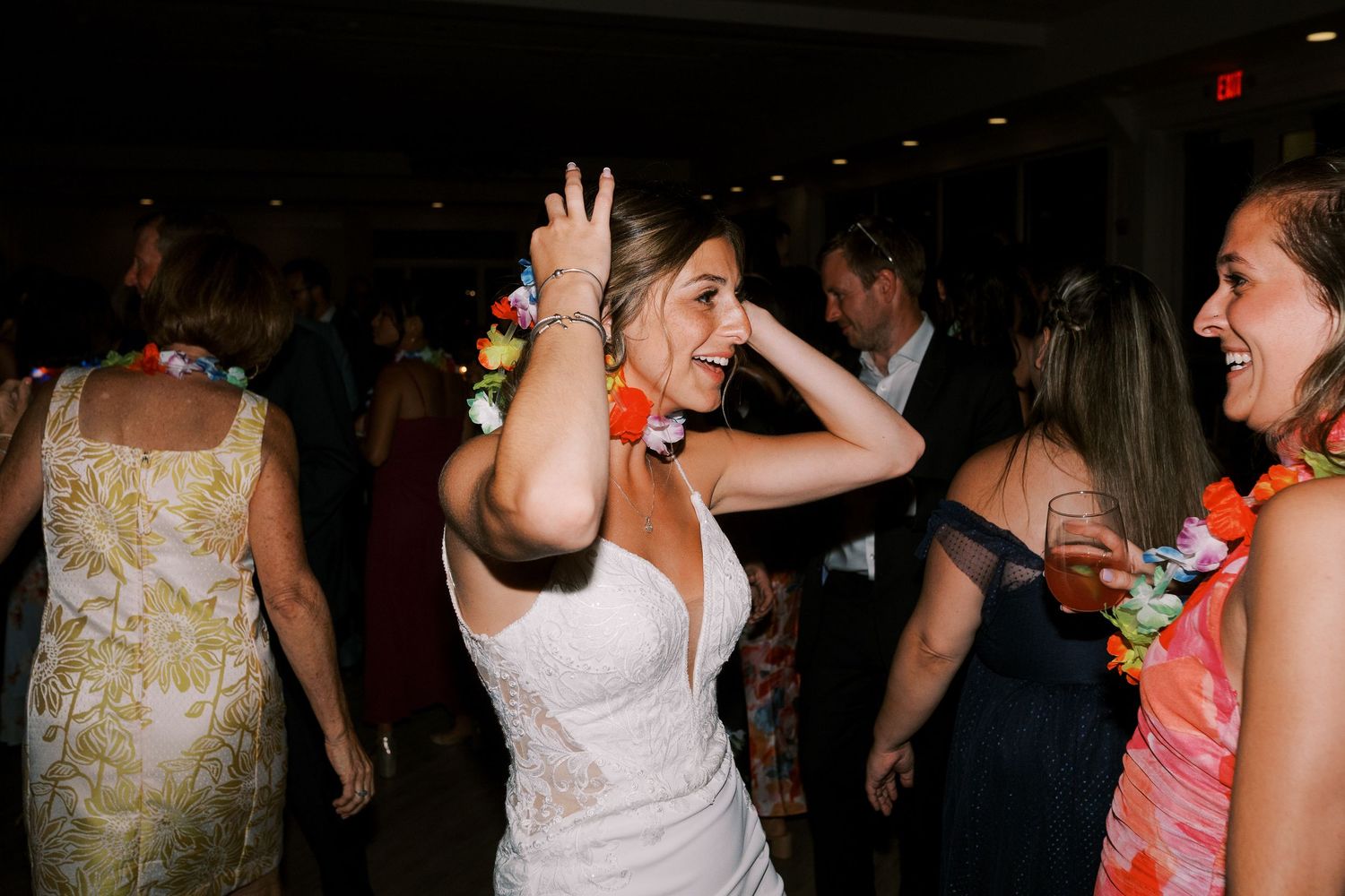 People dancing and socializing at a dimly lit party or nightclub event.