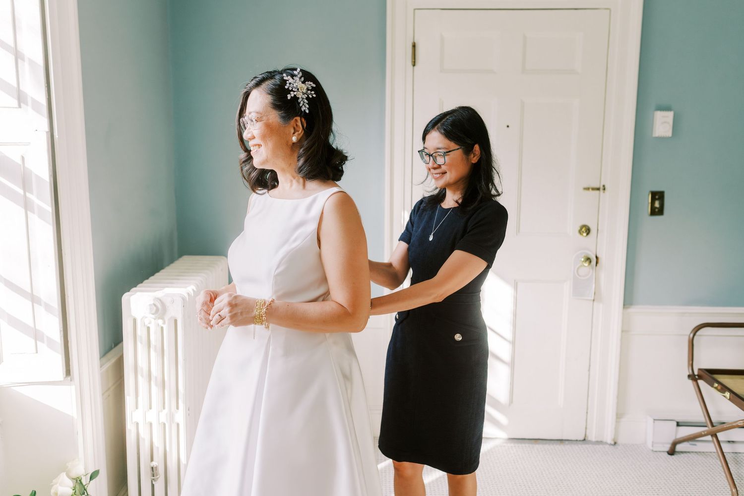 Bridal preparations take place in a sunlit room with turquoise walls and white decor.