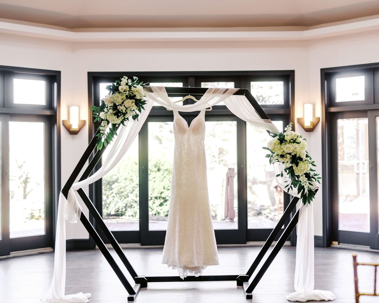 Minimalist wedding venue interior with black-framed windows and white walls.