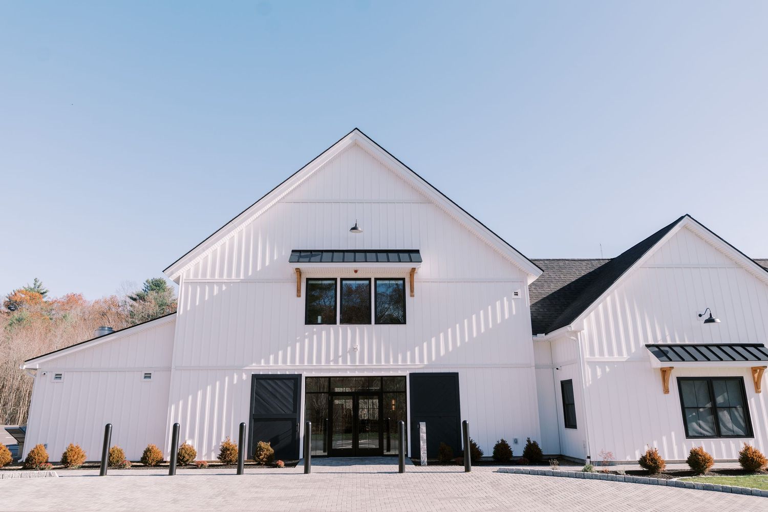 Modern white farmhouse-style building with black accents features a two-story design and clean architectural lines.
