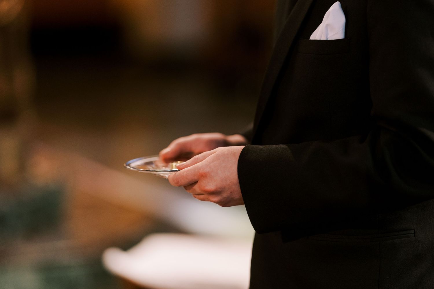 Close-up of hands exchanging rings during a wedding ceremony.