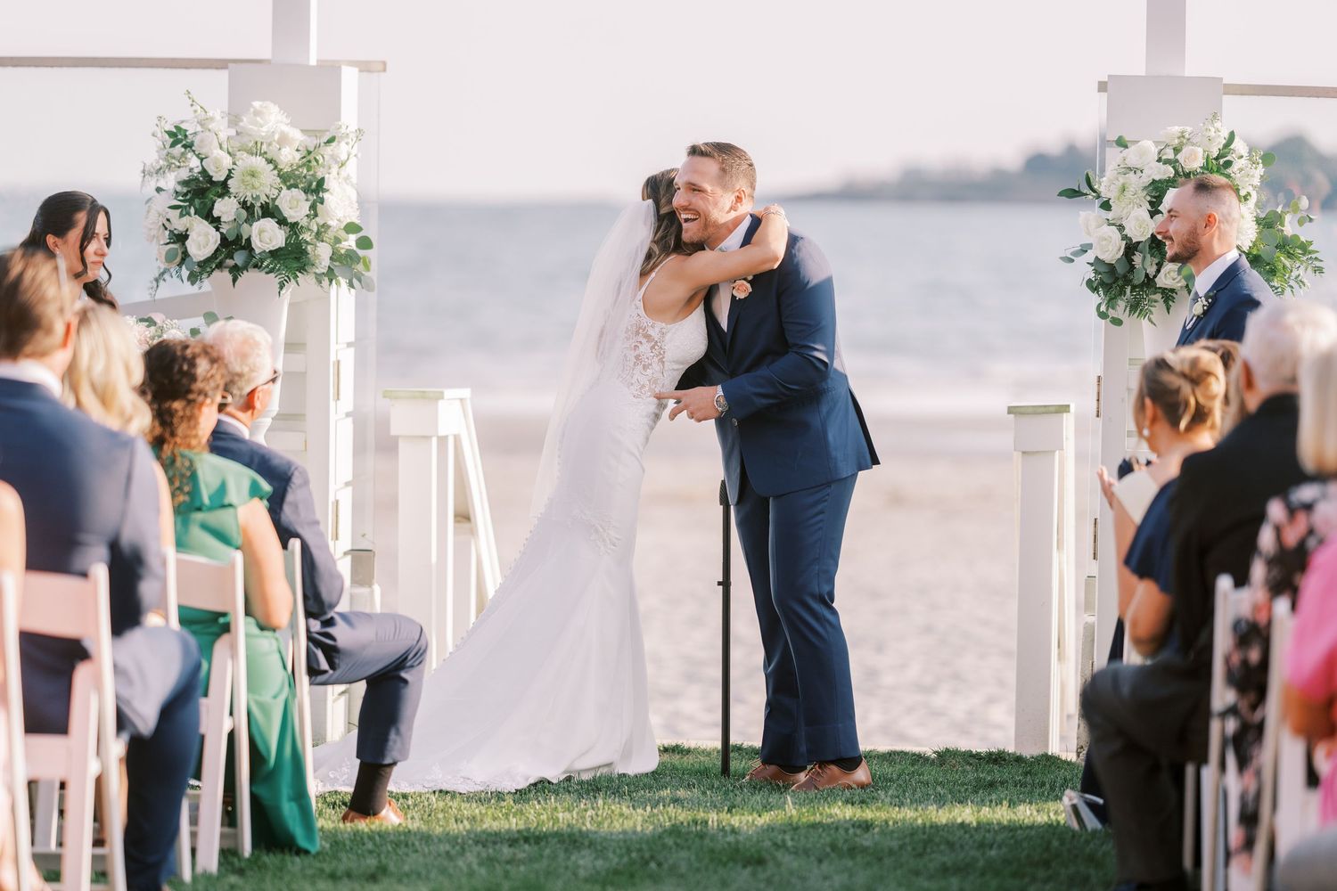 A couple shares romantic moments during their waterfront wedding photoshoot at sunset.