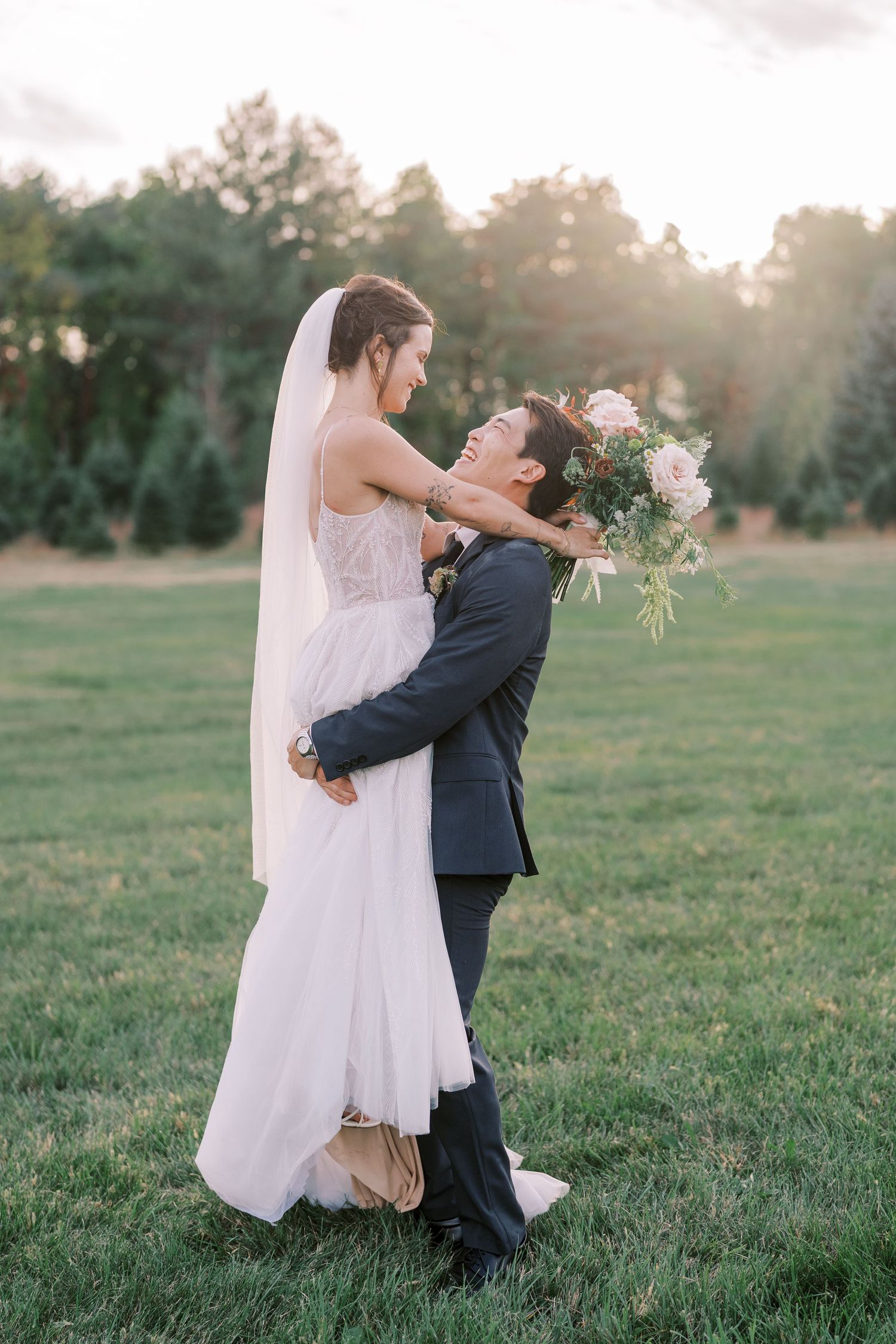 Romantic wedding portrait of couple embracing in golden sunset light.