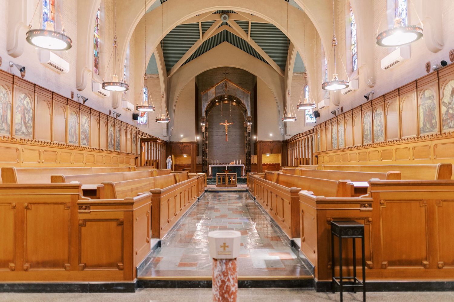 Long wooden corridor with vaulted ceiling and ornate architectural details in warm lighting.