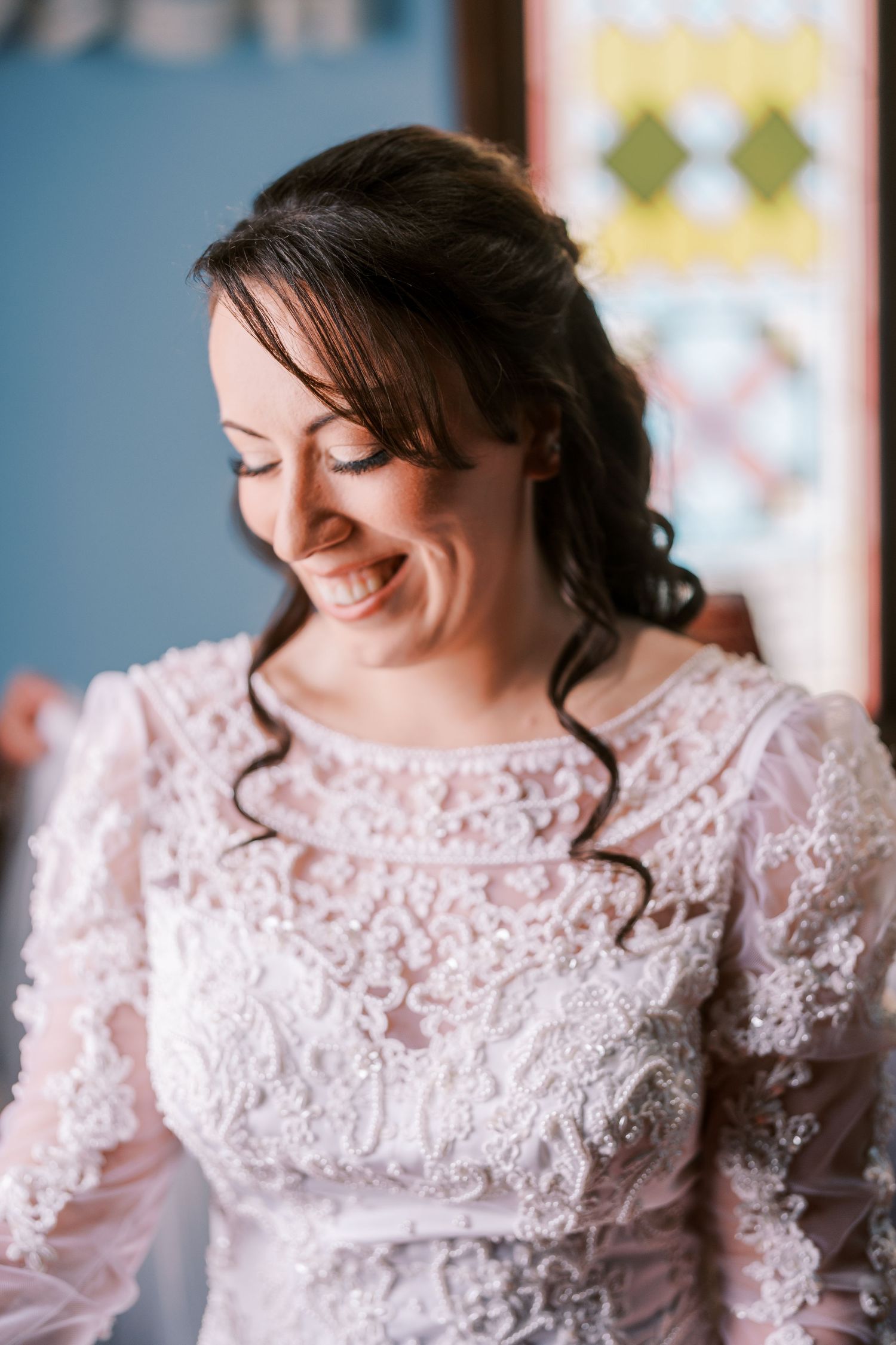 Close-up details of delicate lace and beadwork on a light pink wedding dress bodice.
