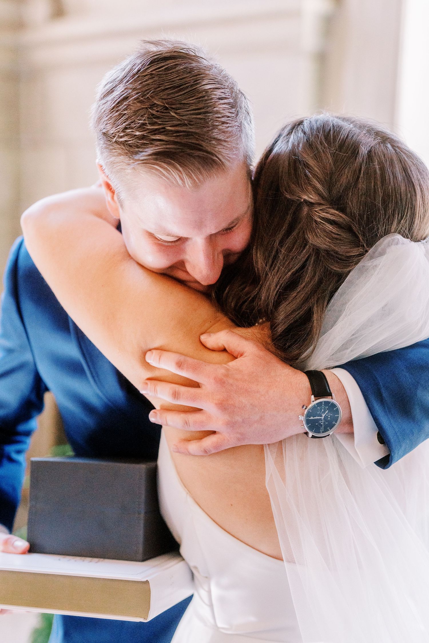 An intimate emotional moment shared between a couple in formal attire during what appears to be a wedding ceremony.