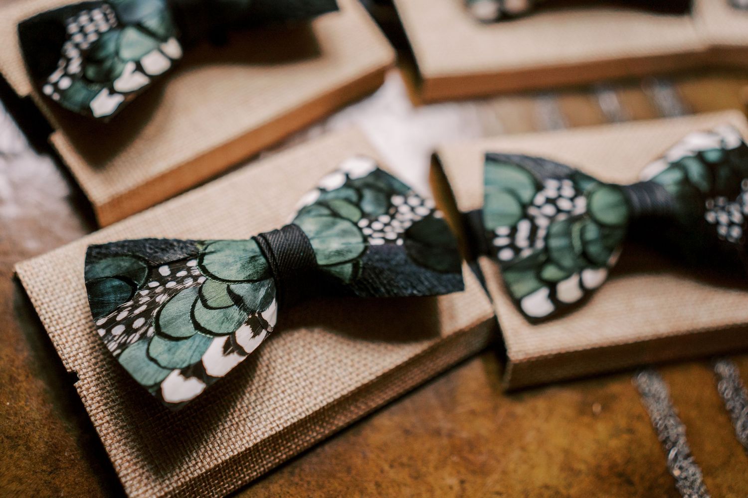 Green butterflies with polka dots on dark wooden bowties arranged in a decorative pattern against a textured backdrop.