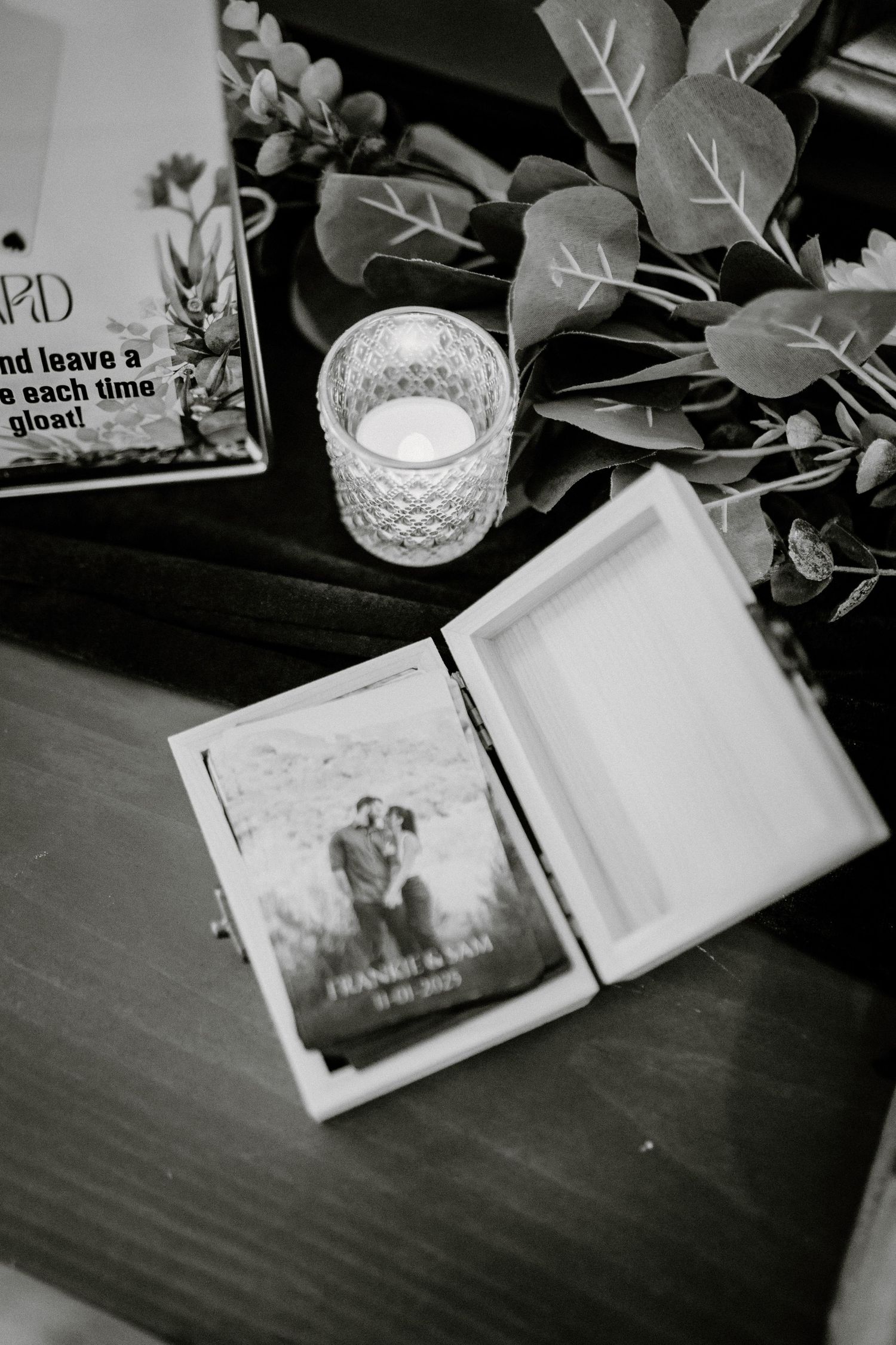 Black and white photo series showing an open book or photo album with pages being turned on a dark wooden surface.