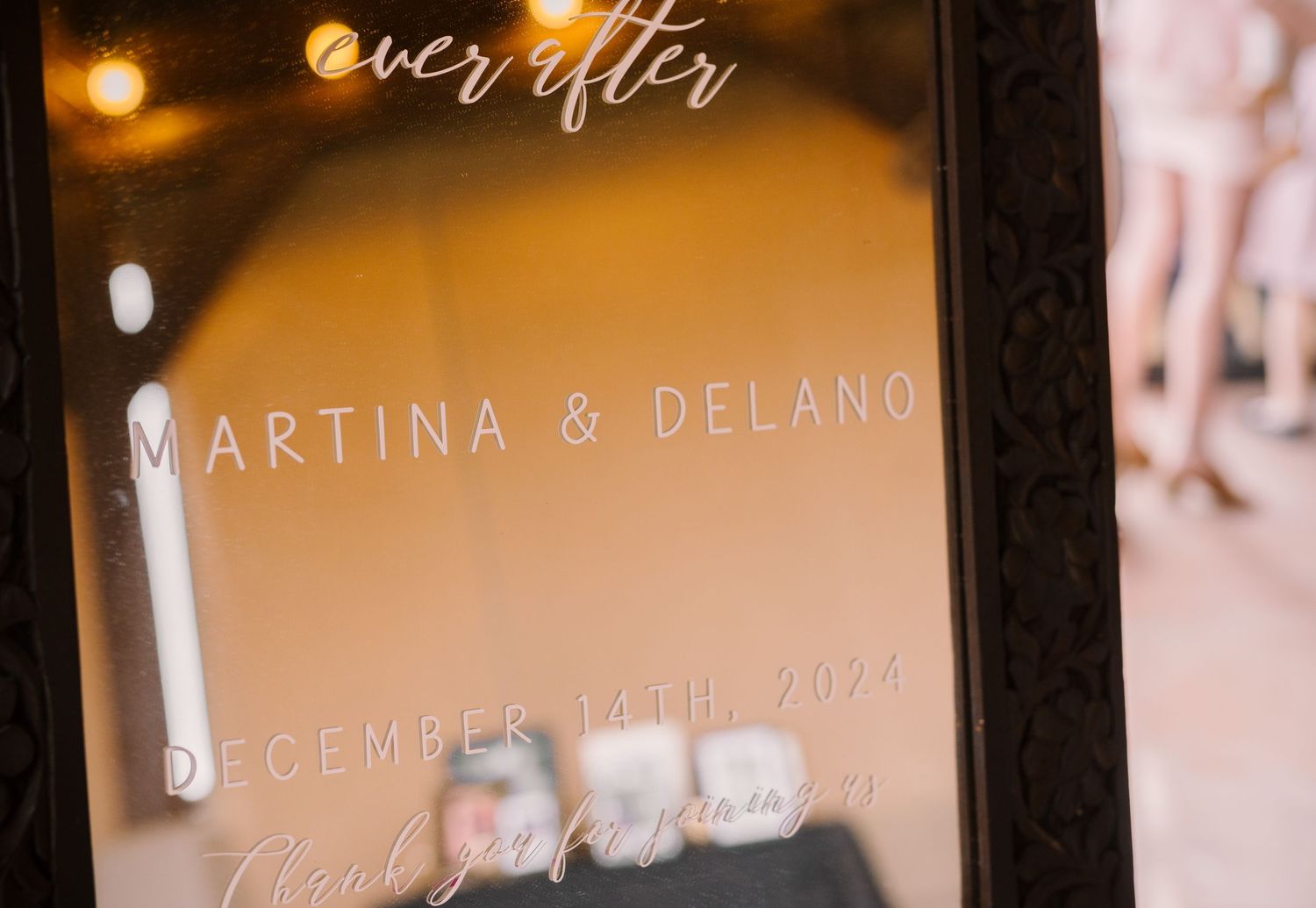 A frosted window displays 'ever after' text with a wedding date in elegant script lettering, lit by warm ambient lighting.