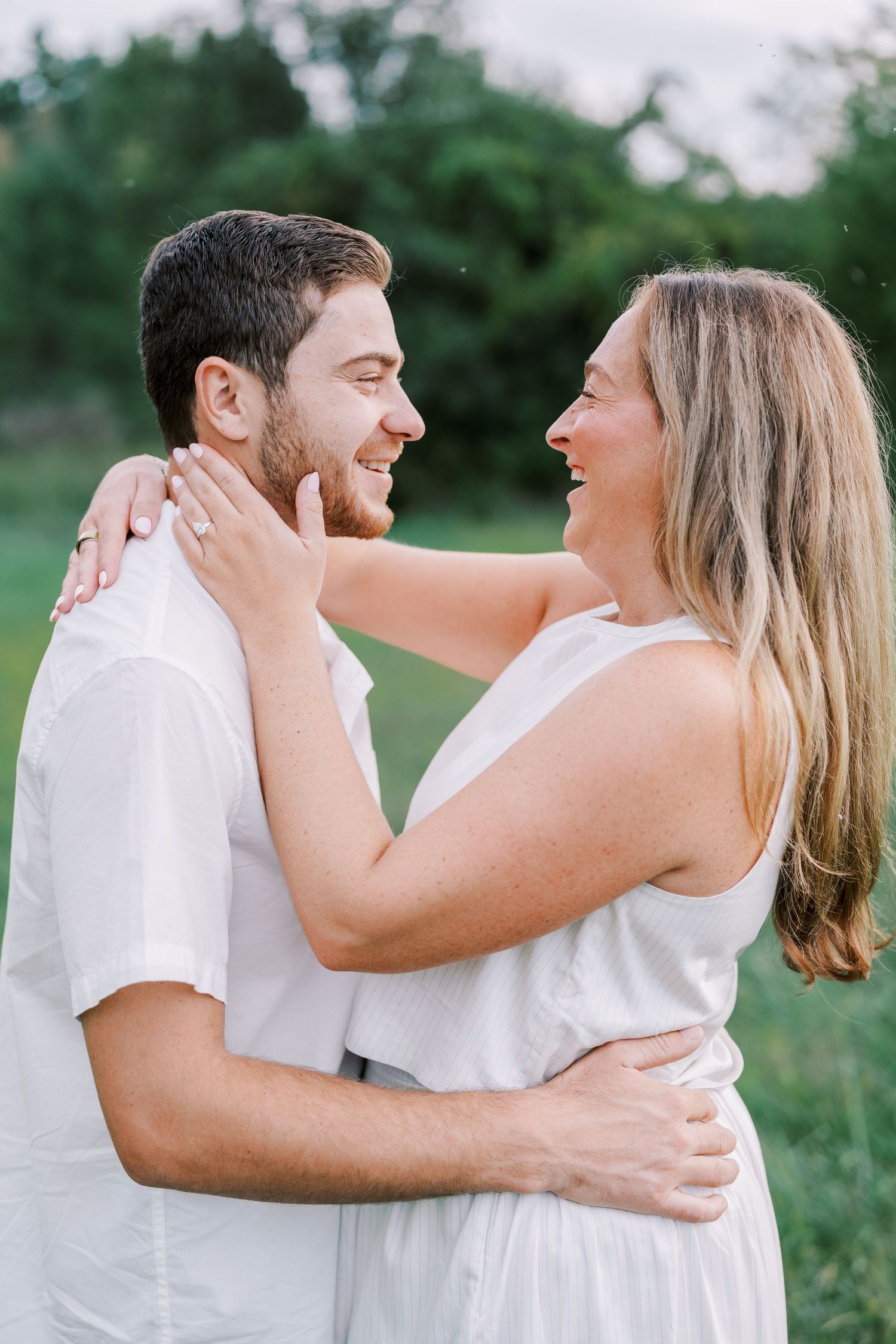 A couple in white outfits shares romantic moments together in a series of outdoor photos.
