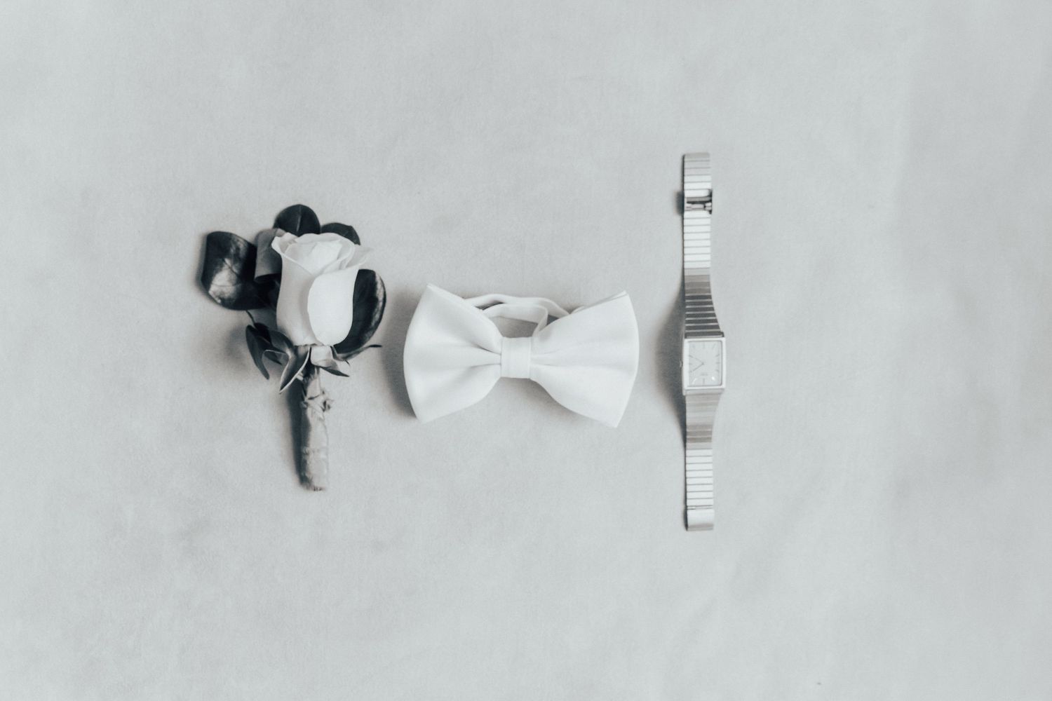 A minimalist flat lay arrangement of white paper bows against a light neutral background.