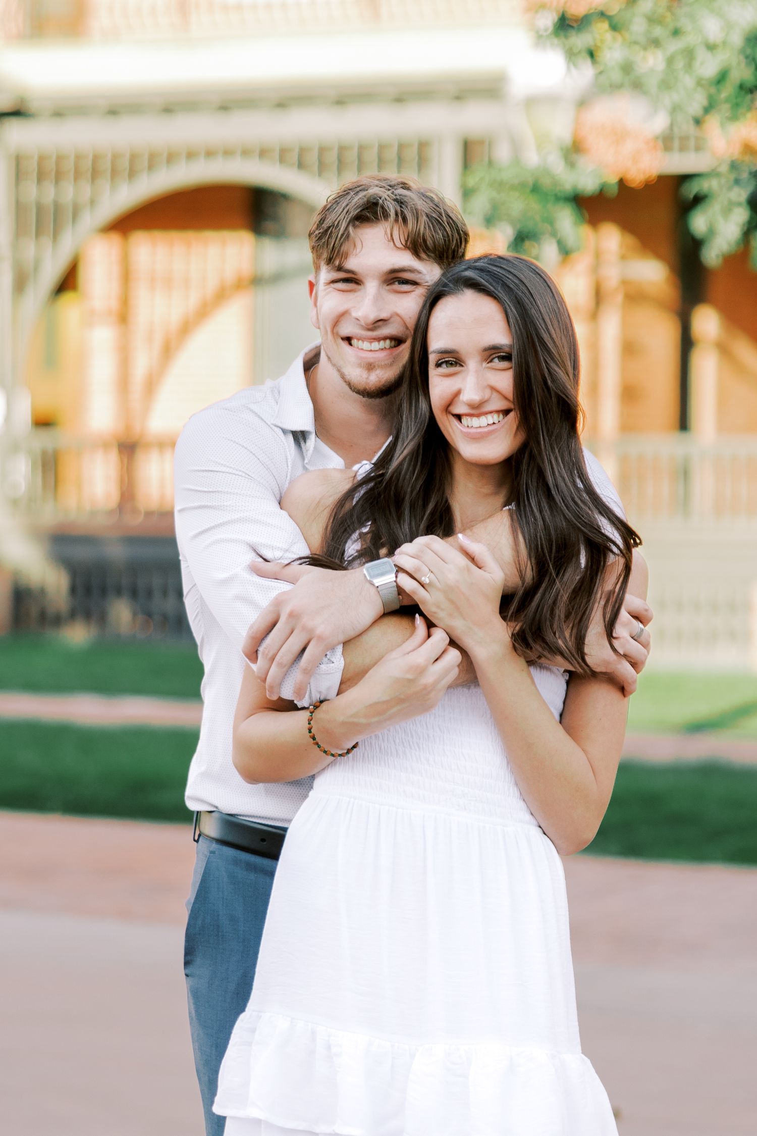 Joyful couple embracing and laughing together in an outdoor garden setting.