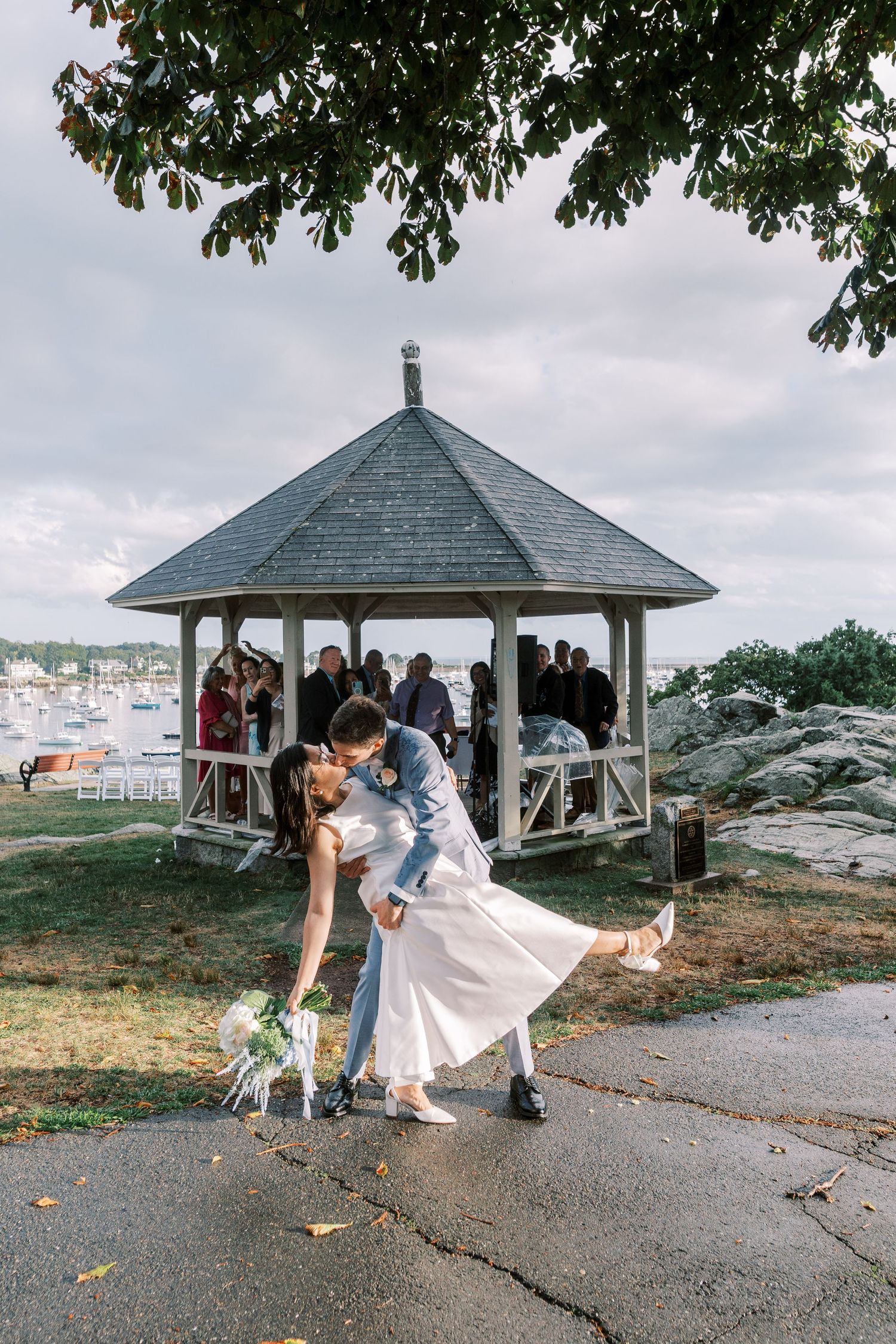 Romantic moments captured under a gazebo with scenic coastal views.