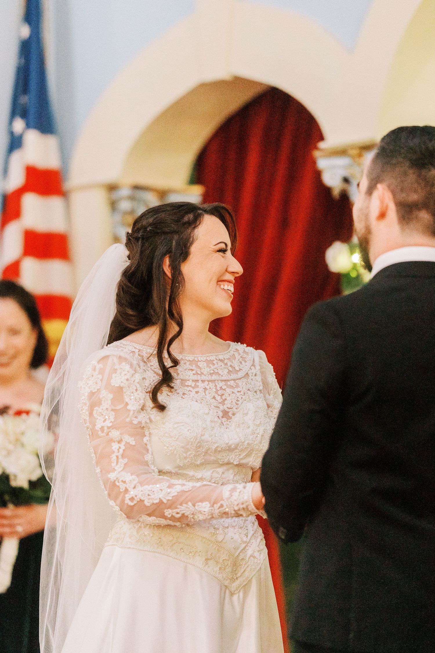 A joyful wedding ceremony moment captured in a church with American flags.