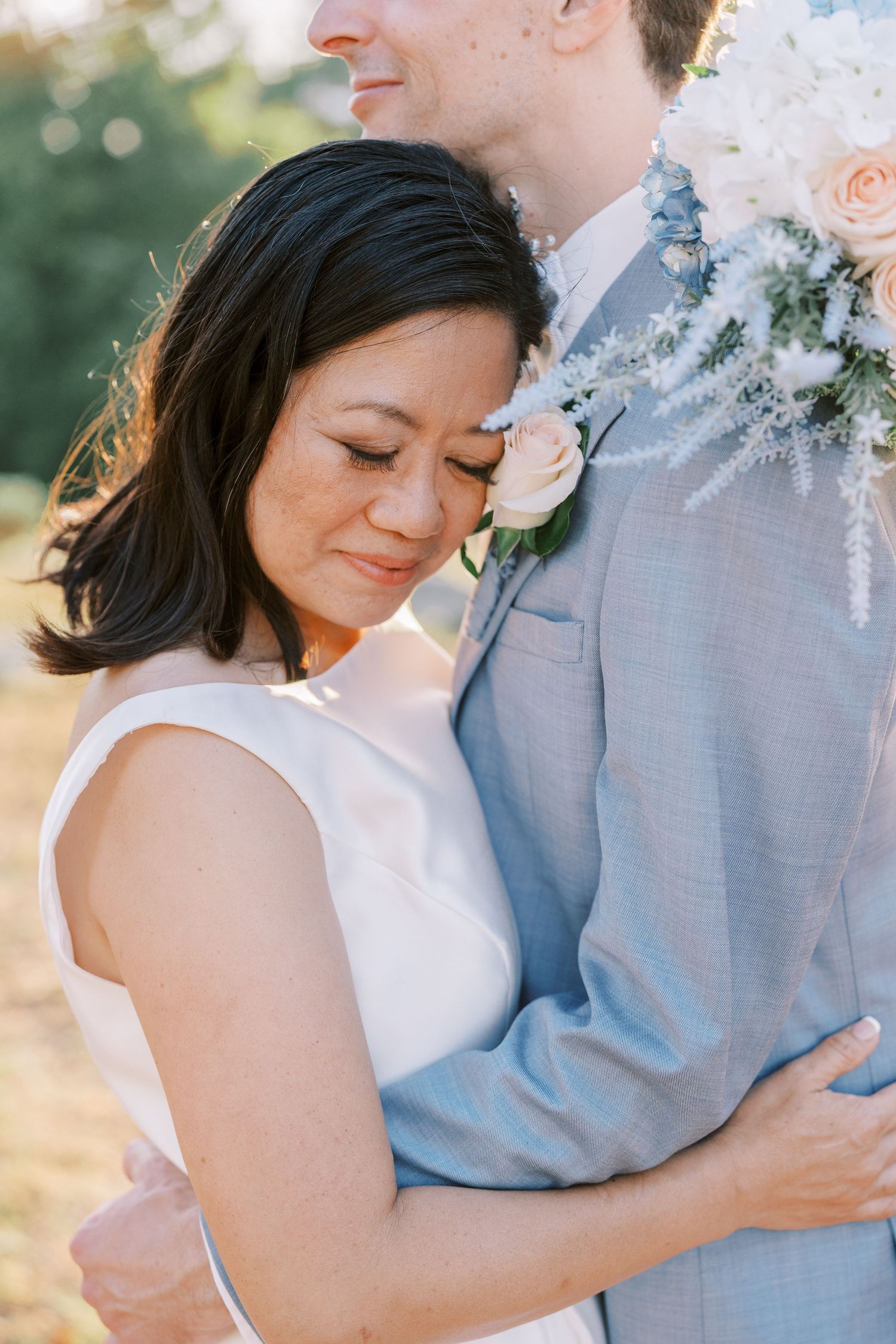 A romantic outdoor wedding photo session showing tender moments between a couple in light blue and white attire.