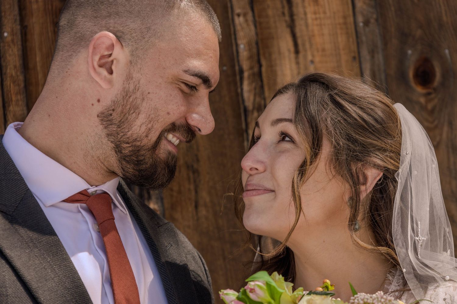Romantic moment between newlyweds in rustic barn setting.