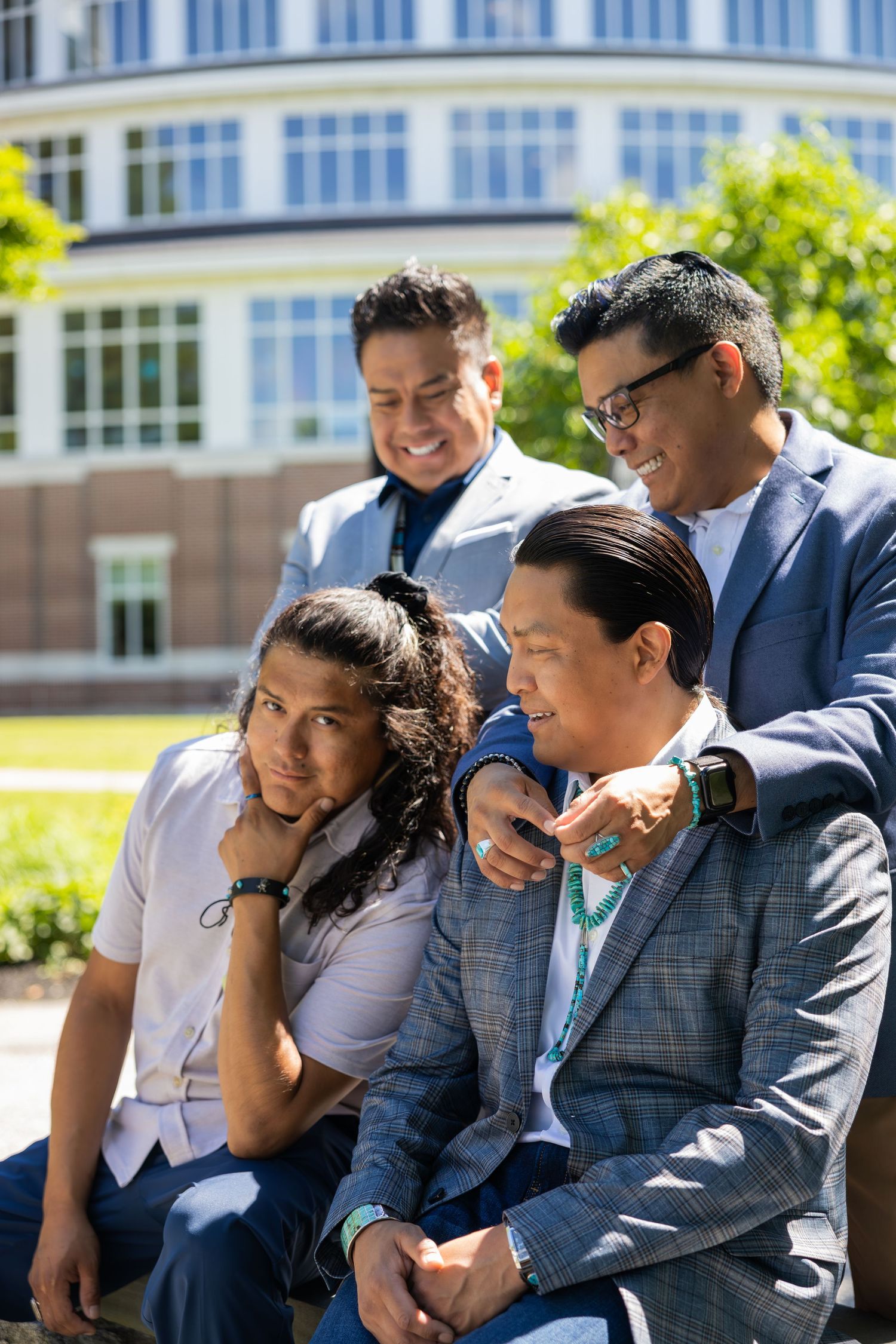 Group of people in business attire sitting together outdoors on a sunny day.