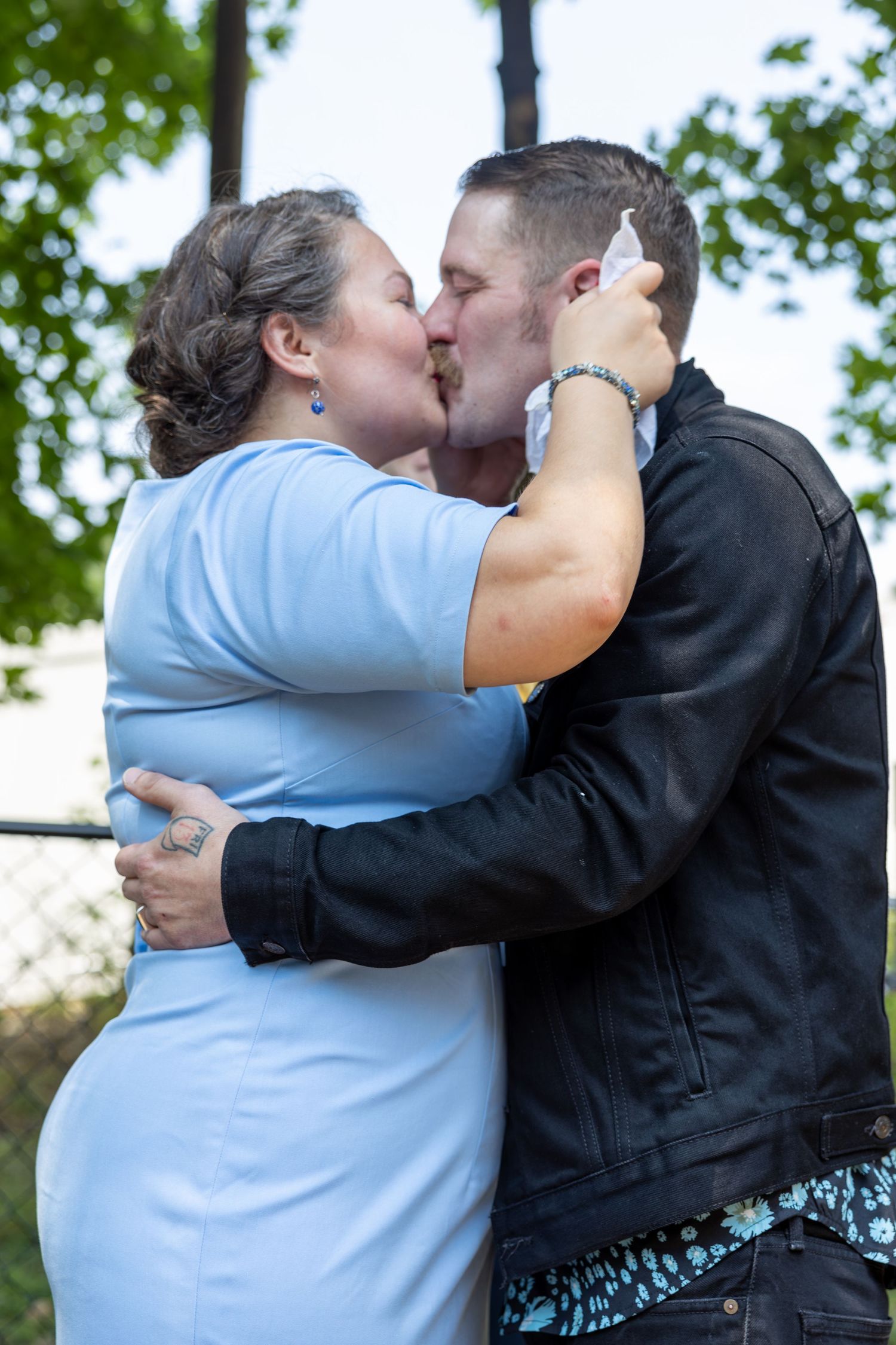 Couple sharing an intimate moment outdoors in casual attire.