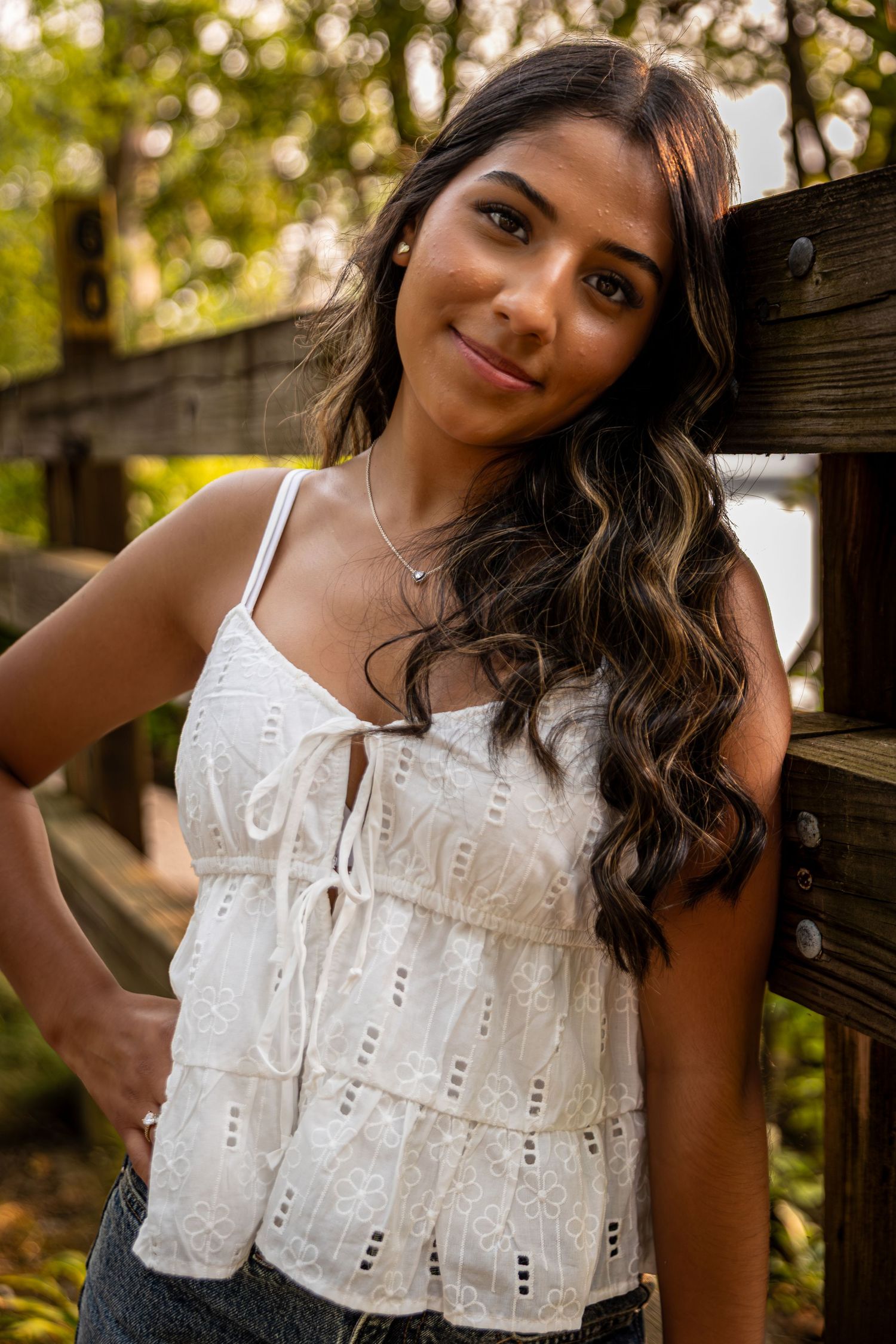 White eyelet lace top with ruffle details photographed in natural outdoor lighting.