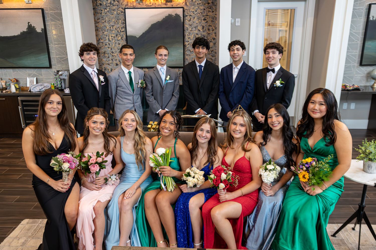 Formal group photo of prom attendees in colorful dresses and suits.