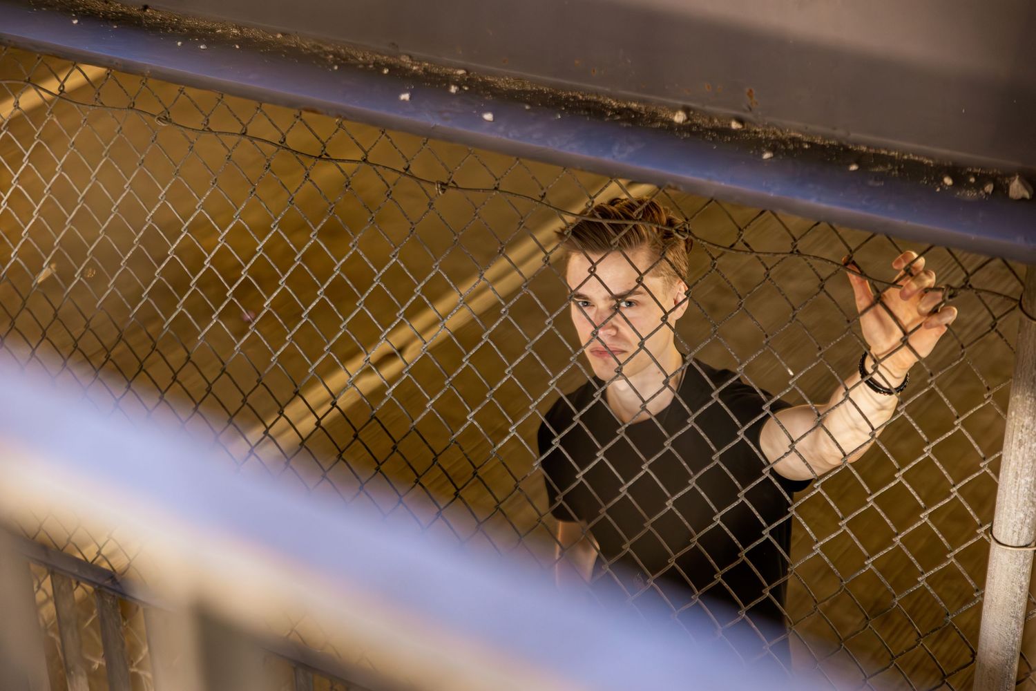 Dark atmospheric shot through chain link fence at night.