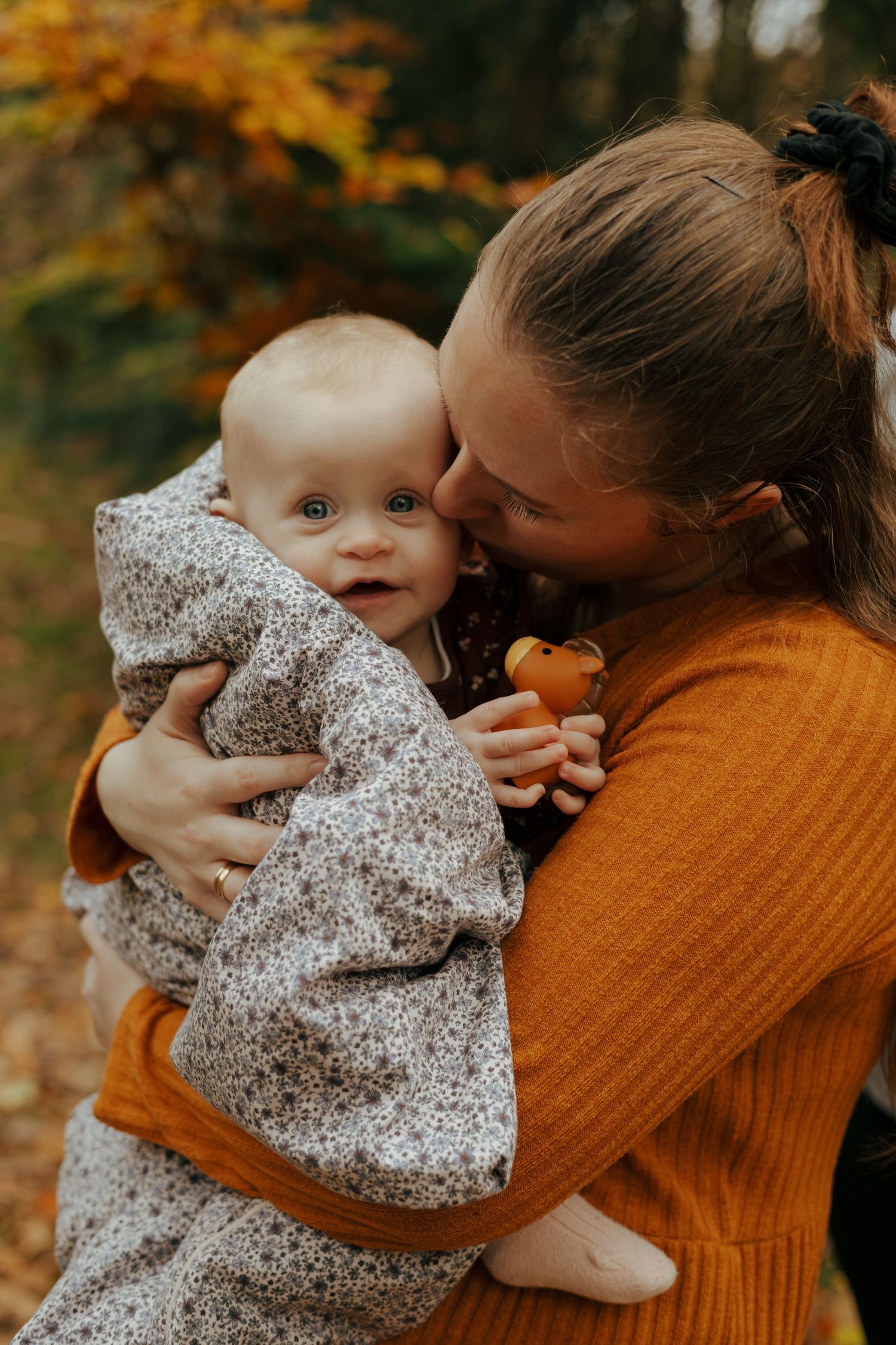A tender autumn moment captured with a baby in floral print clothing.
